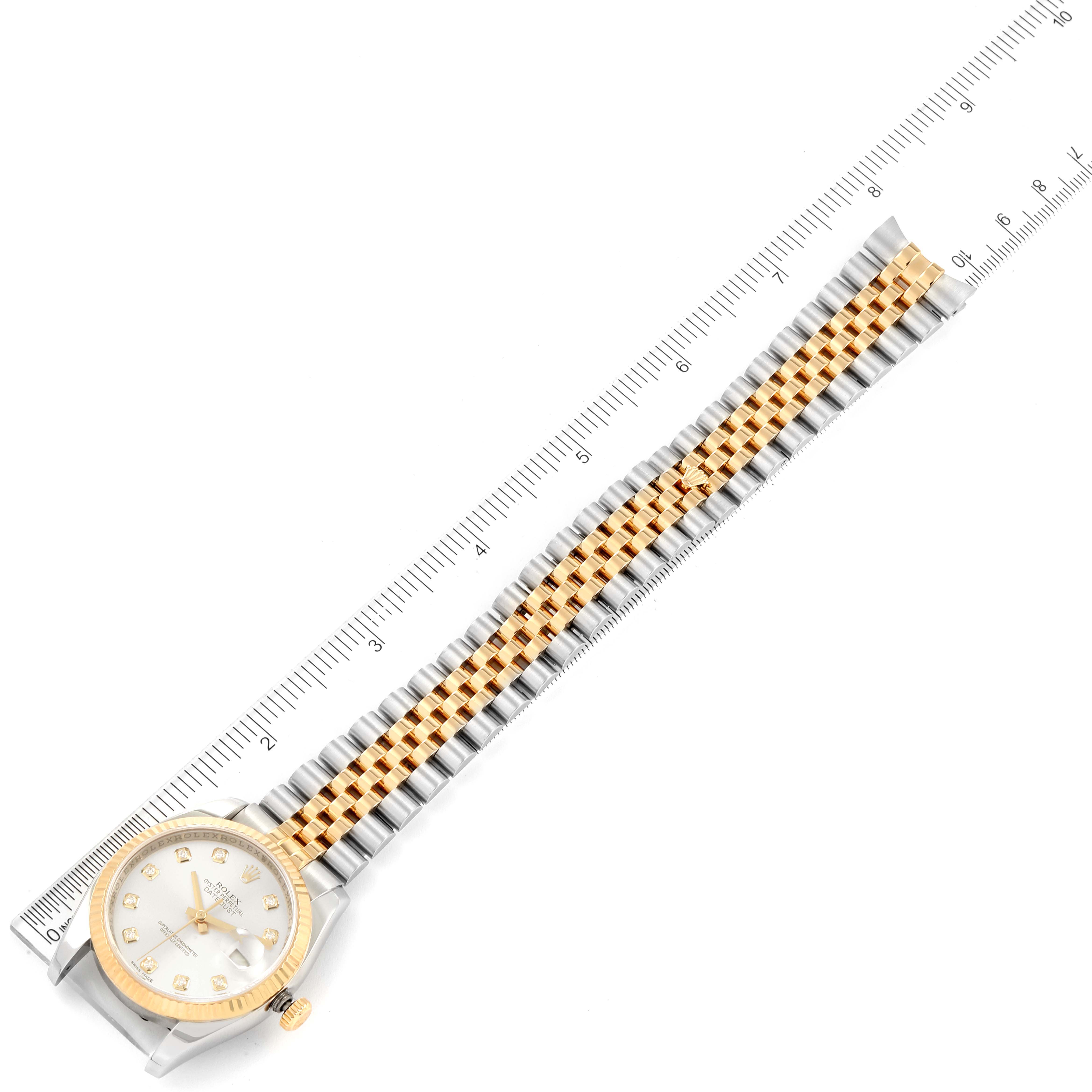 The image shows a Rolex Datejust 116233 Men's Steel and Gold (two tone) Silver Dial 116233 Men's Steel and Gold (two tone) Silver Dial watch laid flat next to a ruler, showcasing the dial, bezel, and bracelet.