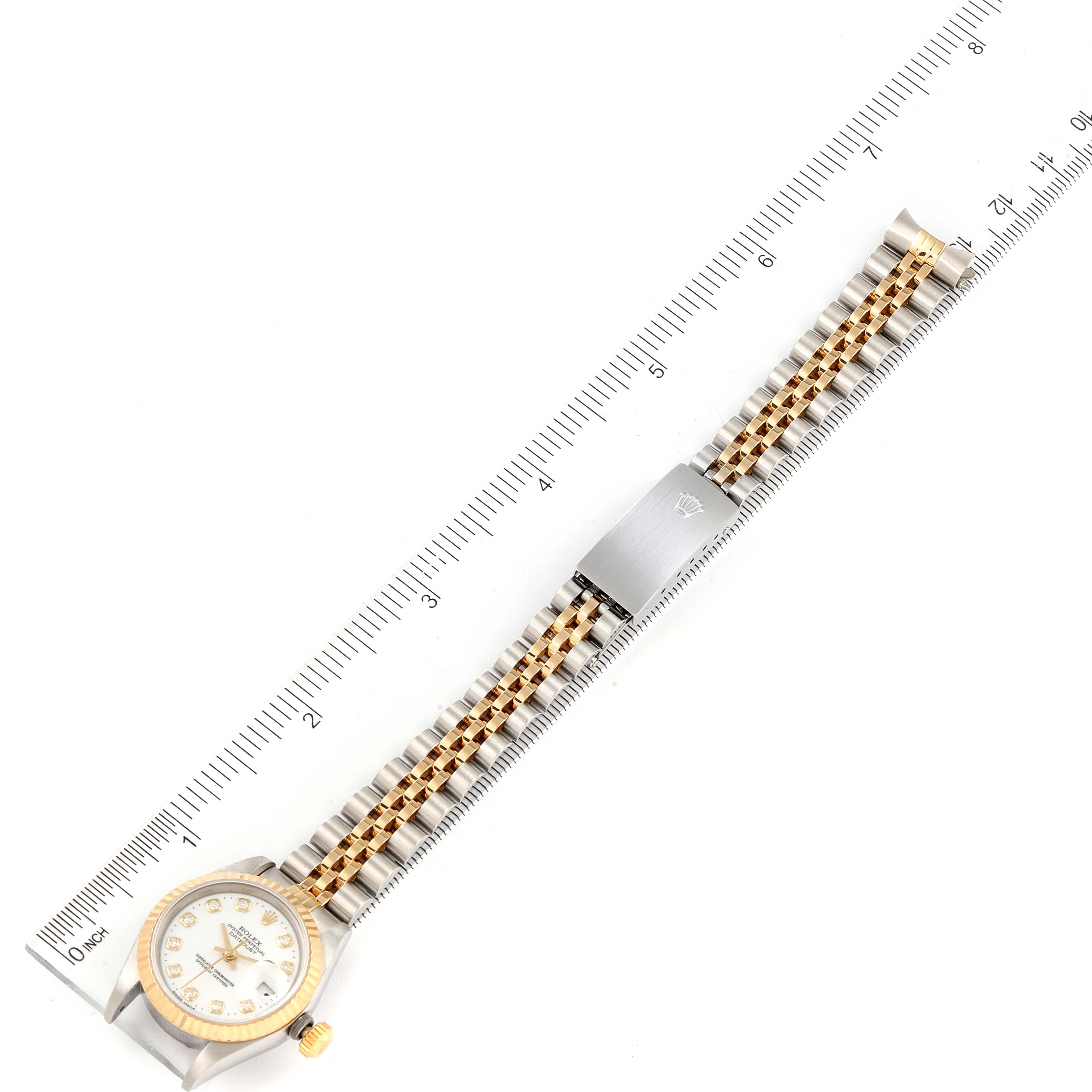 The image shows a Rolex Datejust 69173 Women's Steel and Gold (two tone) White Dial 69173 Women's Steel and Gold (two tone) White Dial watch laid flat against a ruler, displaying the watch face, bracelet, and clasp.