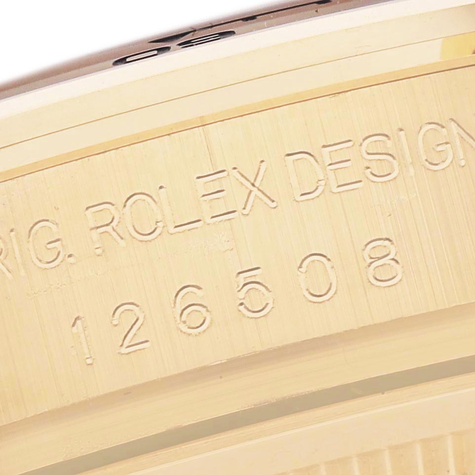 The image shows a detailed side view of the Rolex Daytona 126508 Men
s Yellow Gold Black Dial 126508 Men
s Yellow Gold Black Dial model
s case, highlighting engraving details.