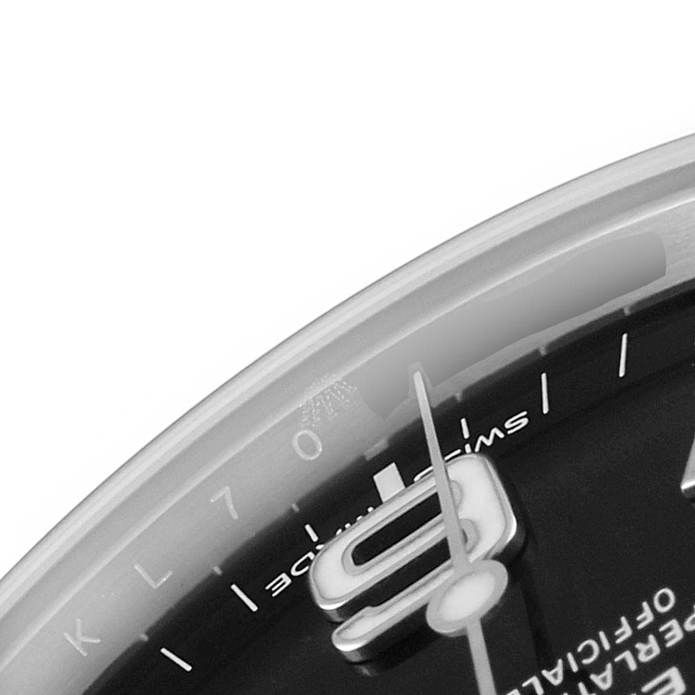 The image shows a close-up of the dial and part of the hand of a Rolex Explorer 214270 Men's Stainless Steel Black Dial 214270 Men's Stainless Steel Black Dial watch.