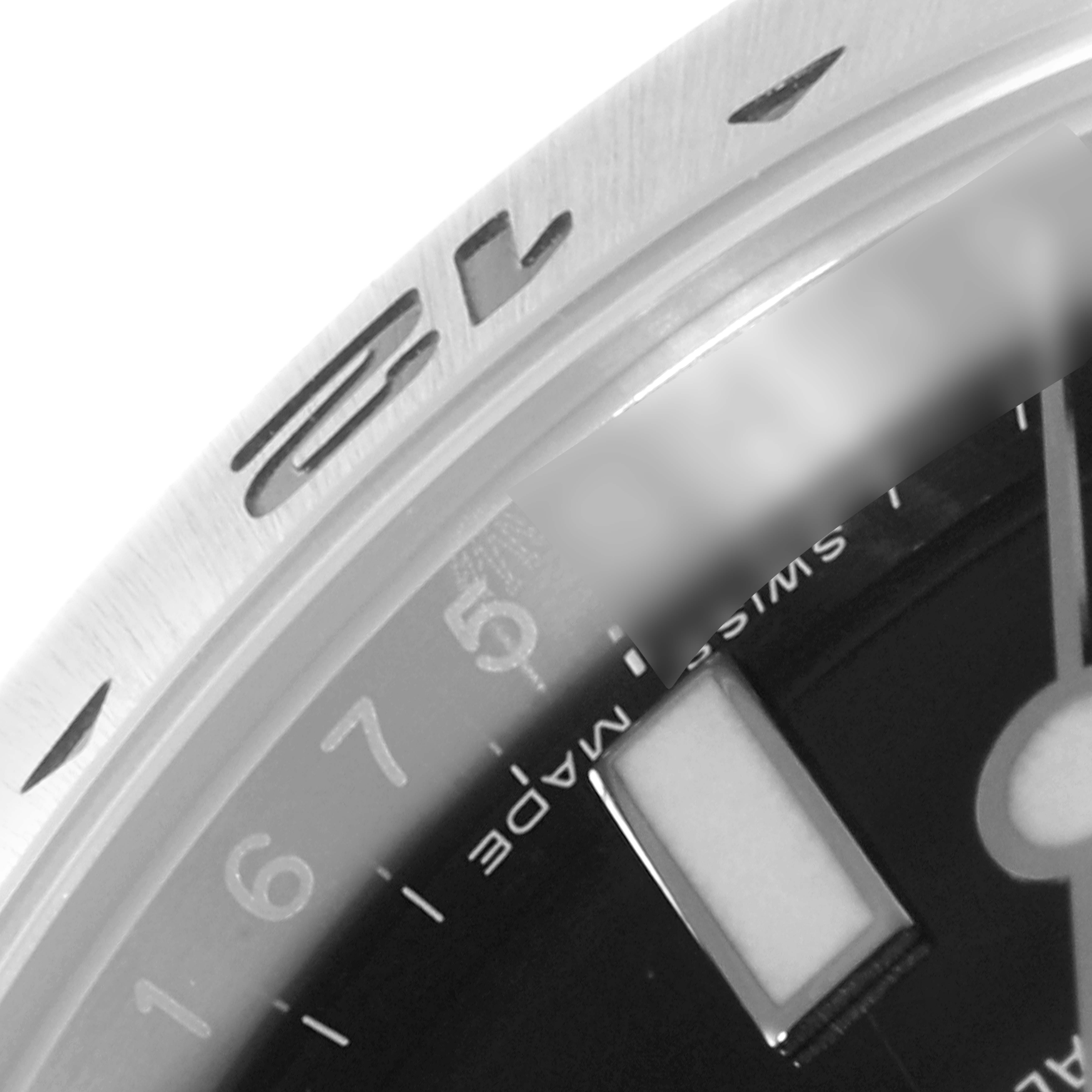 This image shows a close-up of the bezel and part of the dial of a Rolex Explorer 216570 Men
s Stainless Steel Black Dial 216570 Men
s Stainless Steel Black Dial watch, highlighting the "Swiss Made" inscription.