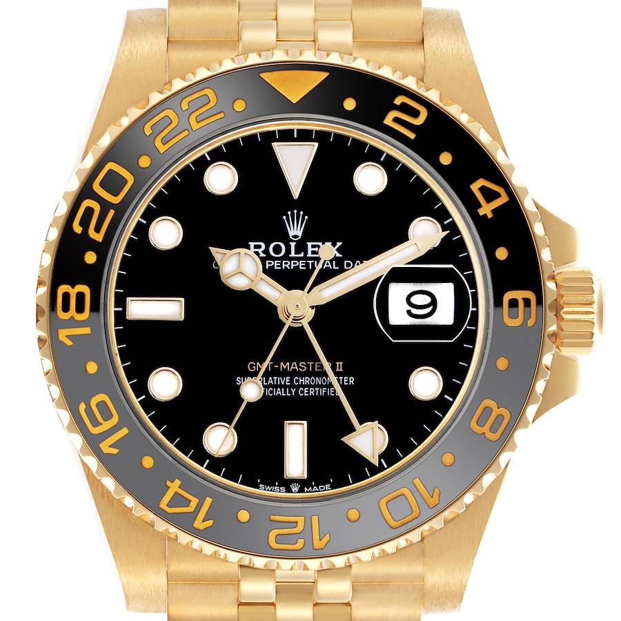 The image shows a Rolex GMT-Master II watch face in a close-up, displaying its black dial, gold bezel, and cyclops lens over the date.