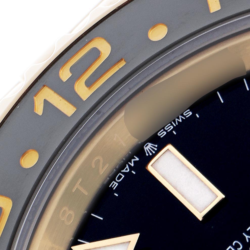 The image shows a close-up of the bezel and dial of the Rolex GMT-Master 126718GRNR Men
s Yellow Gold Black Dial 126718GRNR Men
s Yellow Gold Black Dial, highlighting the 12 o
clock marker and part of the dial.