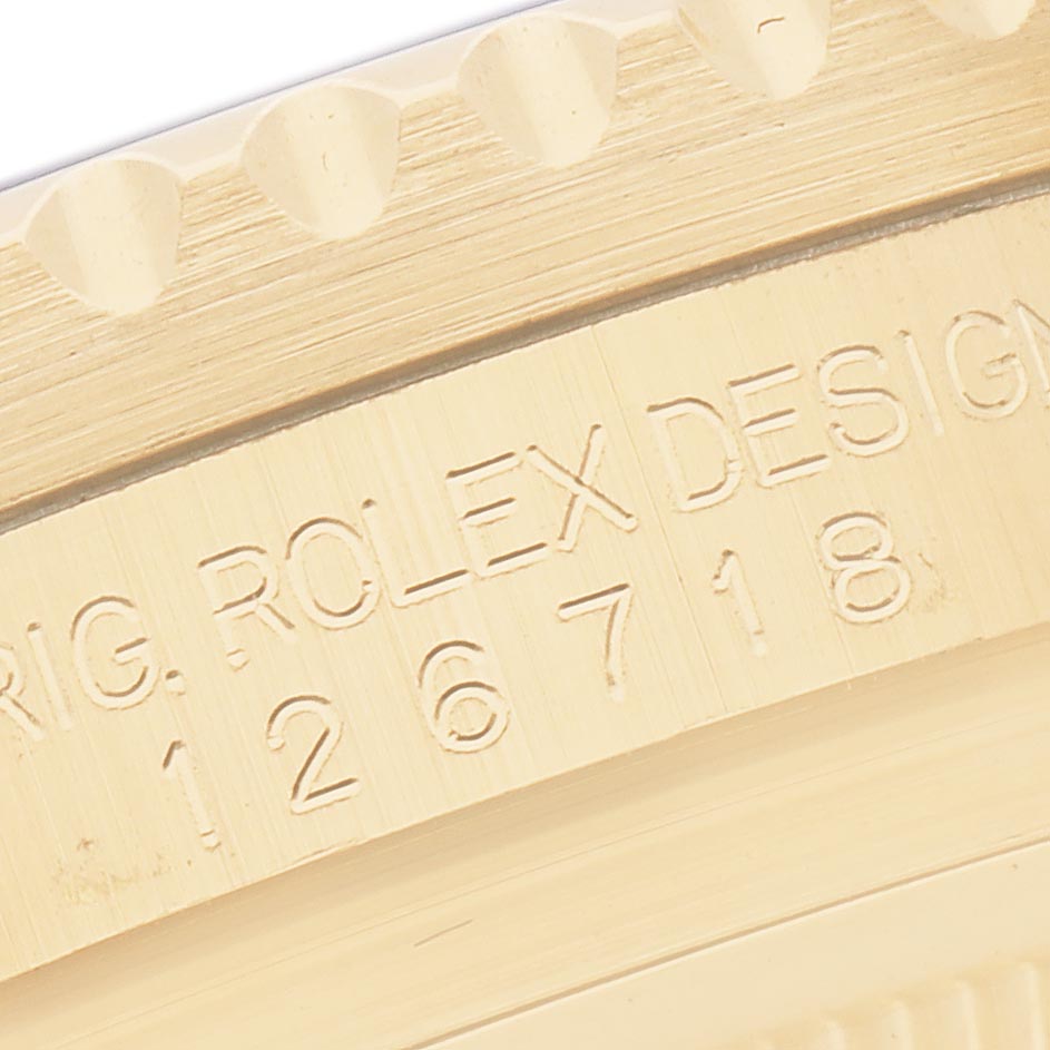 The image shows a close-up of the engraved bezel or case side of a Rolex GMT-Master 126718GRNR Men
s Yellow Gold Black Dial 126718GRNR Men
s Yellow Gold Black Dial watch.