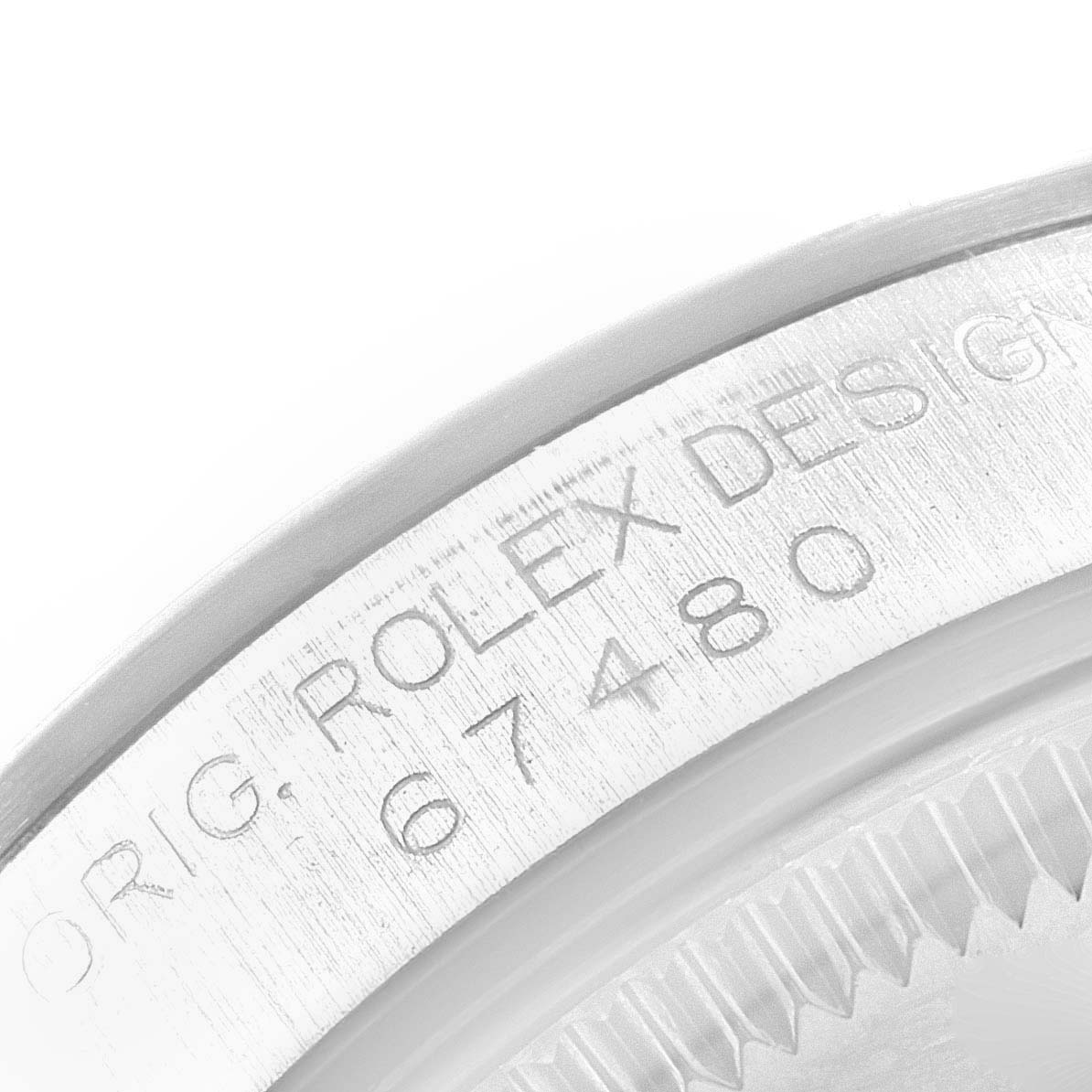 The image shows a close-up of the engraved case back of a Rolex Mid-Size 67480 Women
s Stainless Steel Pink Dial 67480 Women
s Stainless Steel Pink Dial model, displaying the model number 67480.