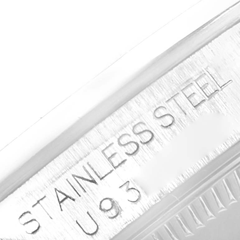 The image shows a close-up angle of the serial number and "STAINLESS STEEL" engraving on a Rolex Mid-Size 67480 Women's Stainless Steel Pink Dial 67480 Women's Stainless Steel Pink Dial watch.