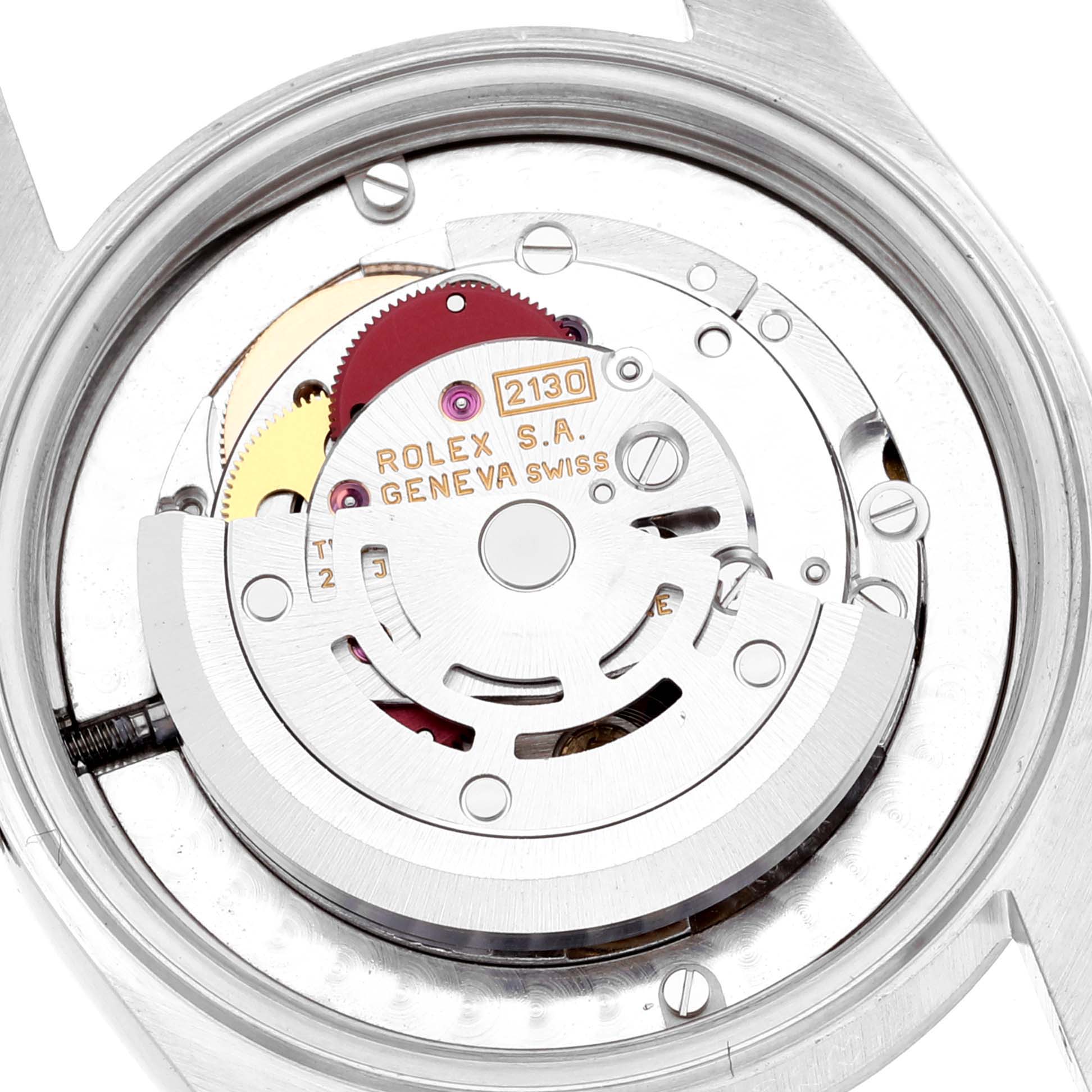 The image shows the exposed mechanical movement of a Mid-Size Rolex watch, highlighting its intricate gears and inner components.