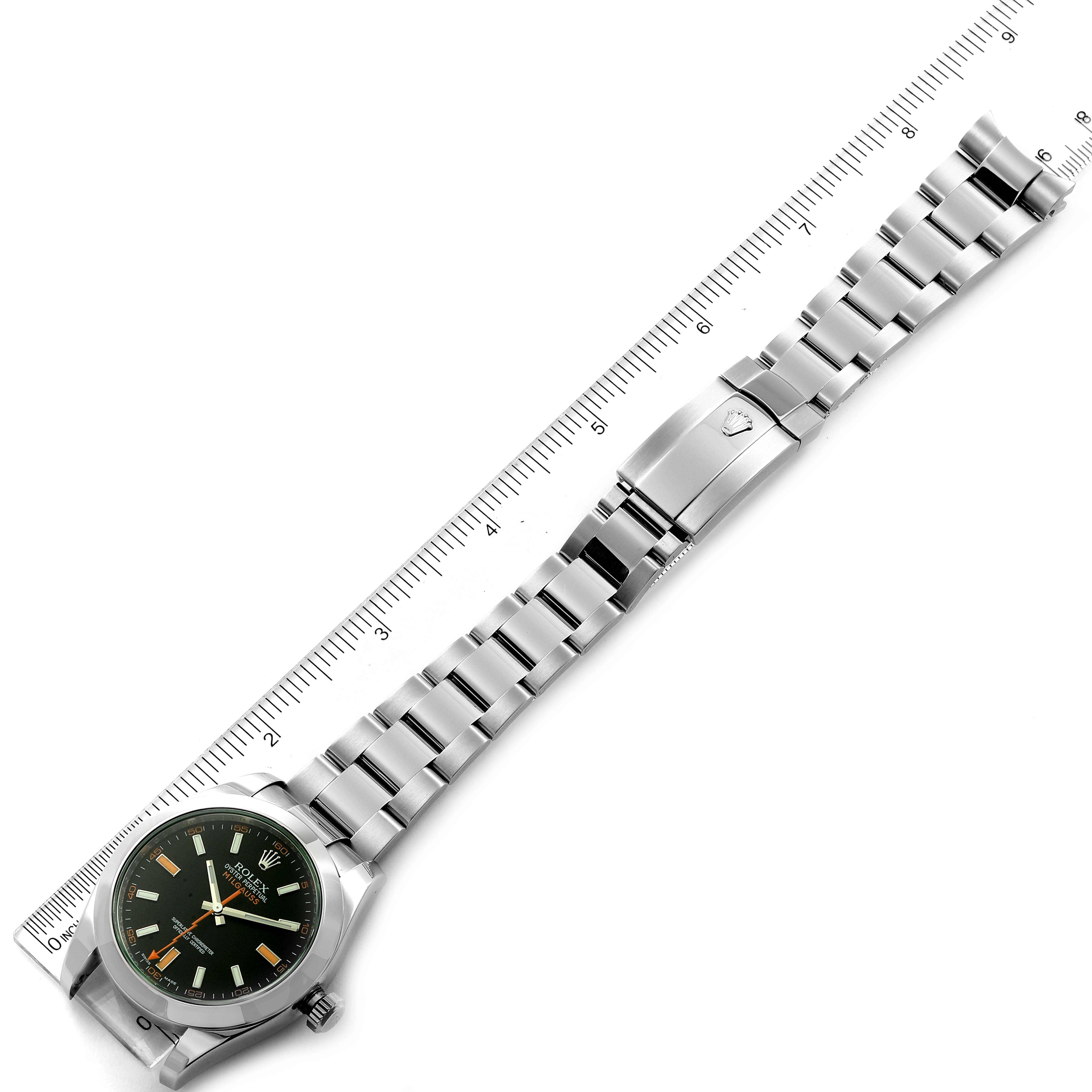 The image shows a top-down angle of a Rolex Milgauss 116400V Men
s Stainless Steel Black Dial 116400V Men
s Stainless Steel Black Dial watch with its full bracelet laid next to a ruler for measurement.