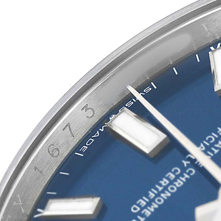 The image shows a close-up of the Rolex Oyster Perpetual 124200 Men's Stainless Steel Blue Dial watch, highlighting the blue dial, hour markers, and part of the bezel.