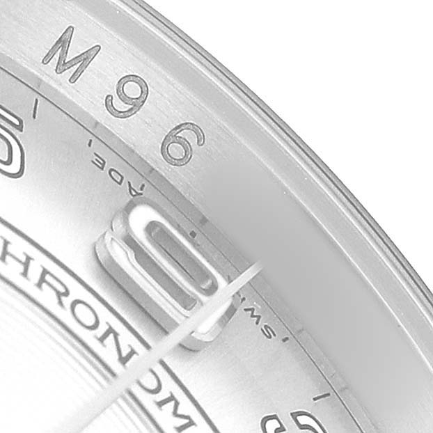 The image shows a detailed view of the edge and part of the dial of a Rolex Oyster Perpetual 116000 Men's Stainless Steel Silver Dial, featuring numbers and markings.
