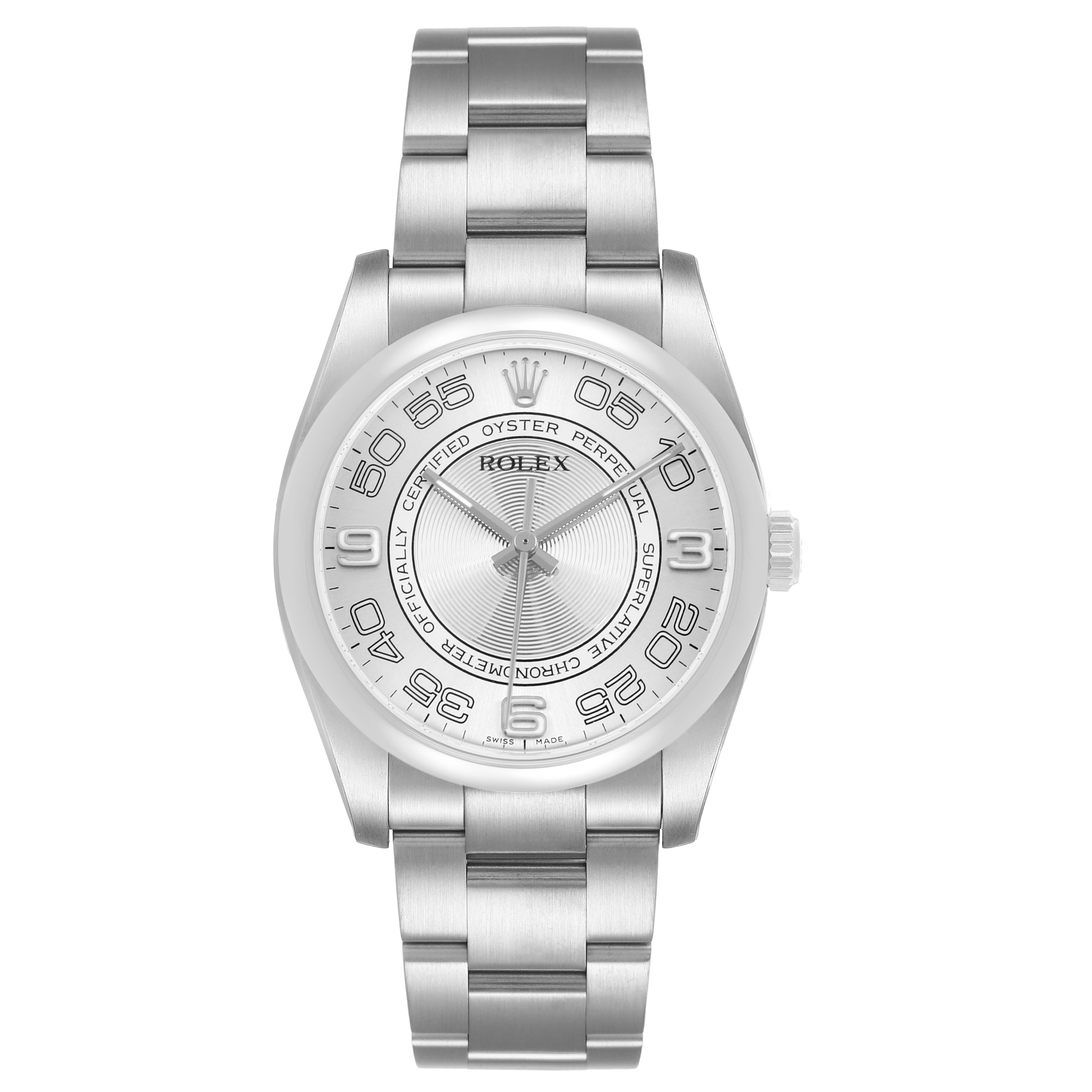 The Rolex Oyster Perpetual 116000 Men's Stainless Steel Silver Dial watch is shown from a top-down angle, highlighting the face, bezel, and stainless steel bracelet.