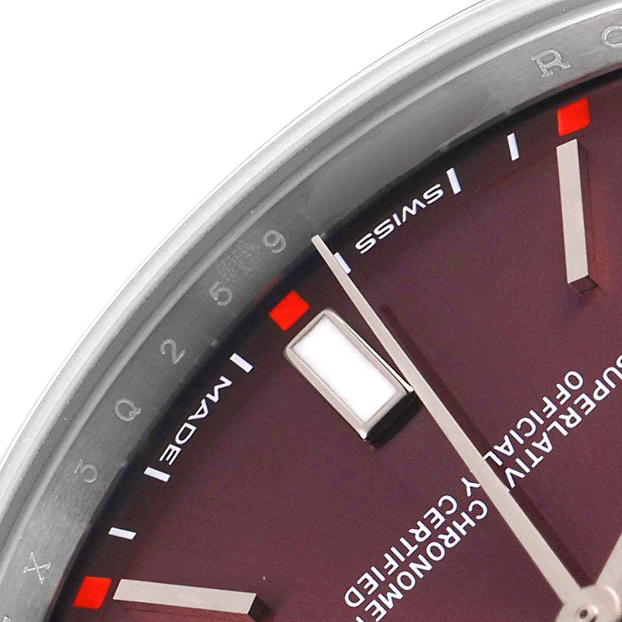 This image shows a close-up angle of the dial and bezel of the Rolex Oyster Perpetual 114300 Men's Stainless Steel Burgundy Dial 114300 Men's Stainless Steel Burgundy Dial watch, highlighting the hour markers and text.