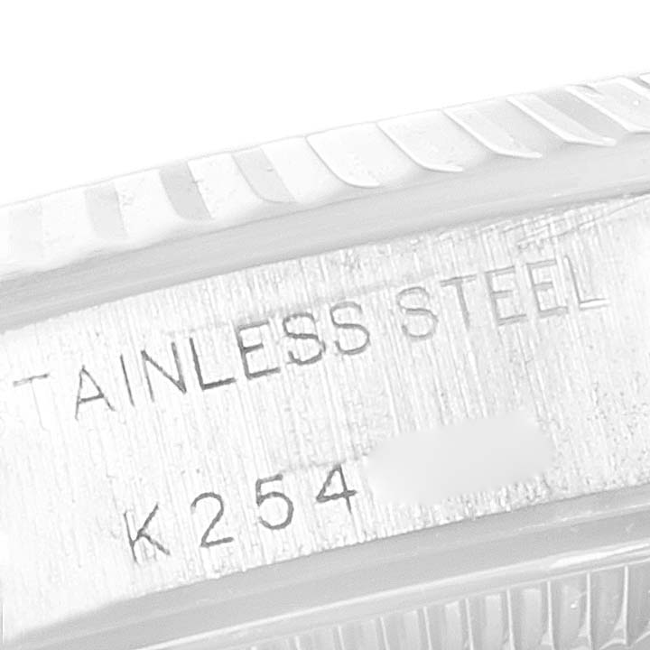 The image shows a close-up of the side of a stainless steel Rolex Oyster Perpetual 76094 Women
s Stainless Steel Pink Dial 76094 Women
s Stainless Steel Pink Dial watch, highlighting the inscription.