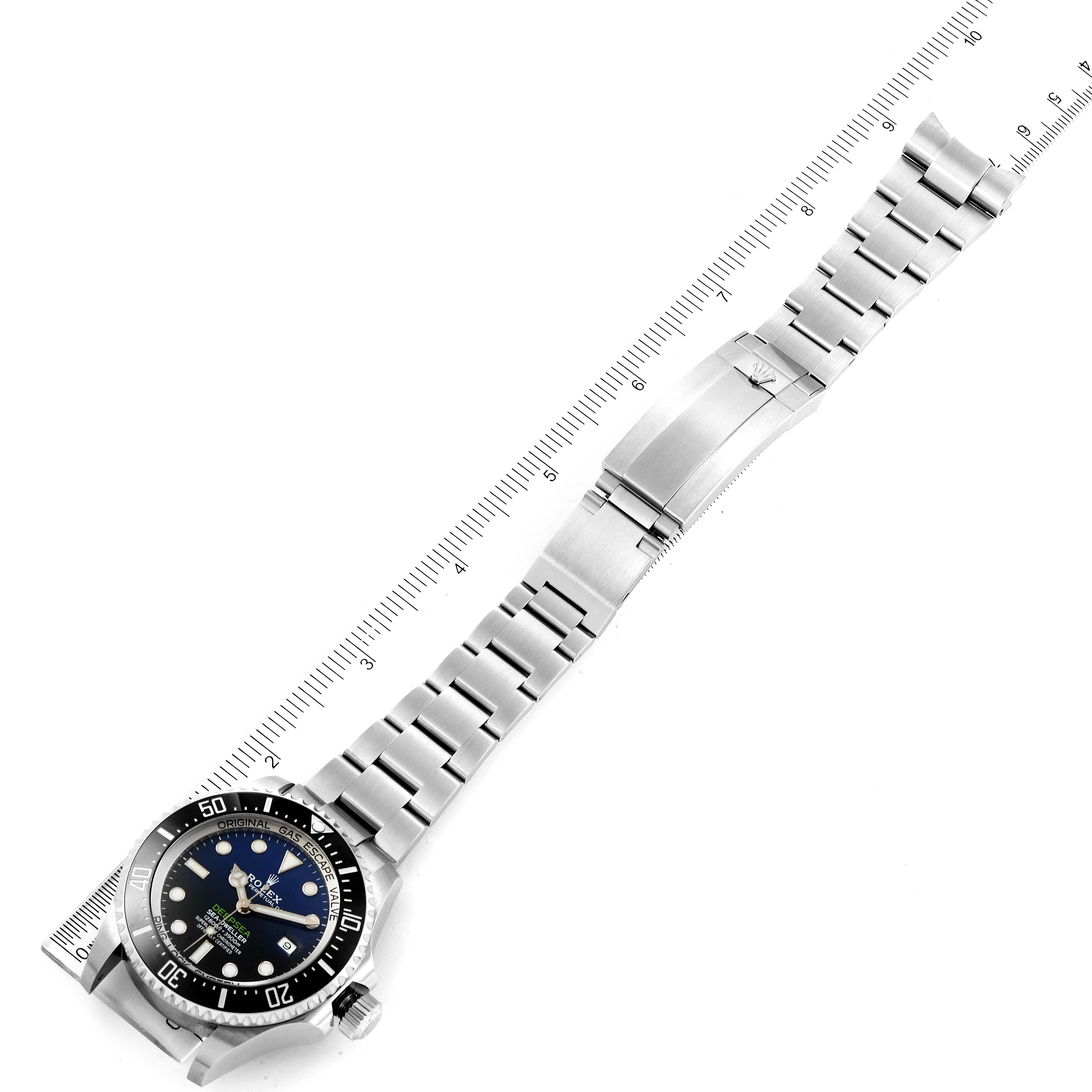 The image shows the Rolex Sea-Dweller 126660 Men
s Stainless Steel Blue Dial 126660 Men
s Stainless Steel Blue Dial watch laid flat, displaying the full bracelet and clasp alongside a measuring ruler.