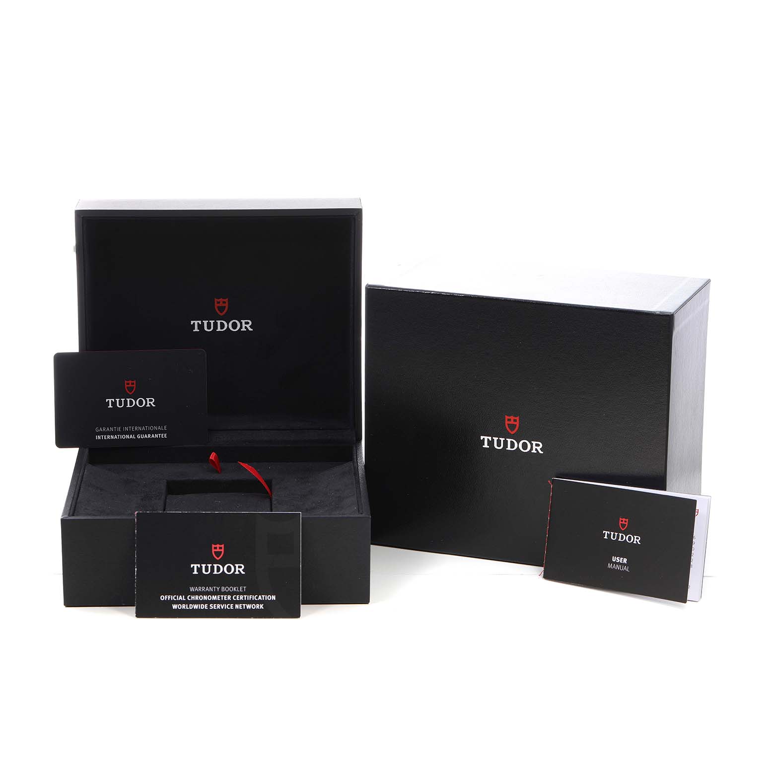 The image shows the packaging and accessories for the Tudor Heritage Black Bay M79360N-0012 Men's Stainless Steel Silver Dial, including a box, warranty card, and manual.