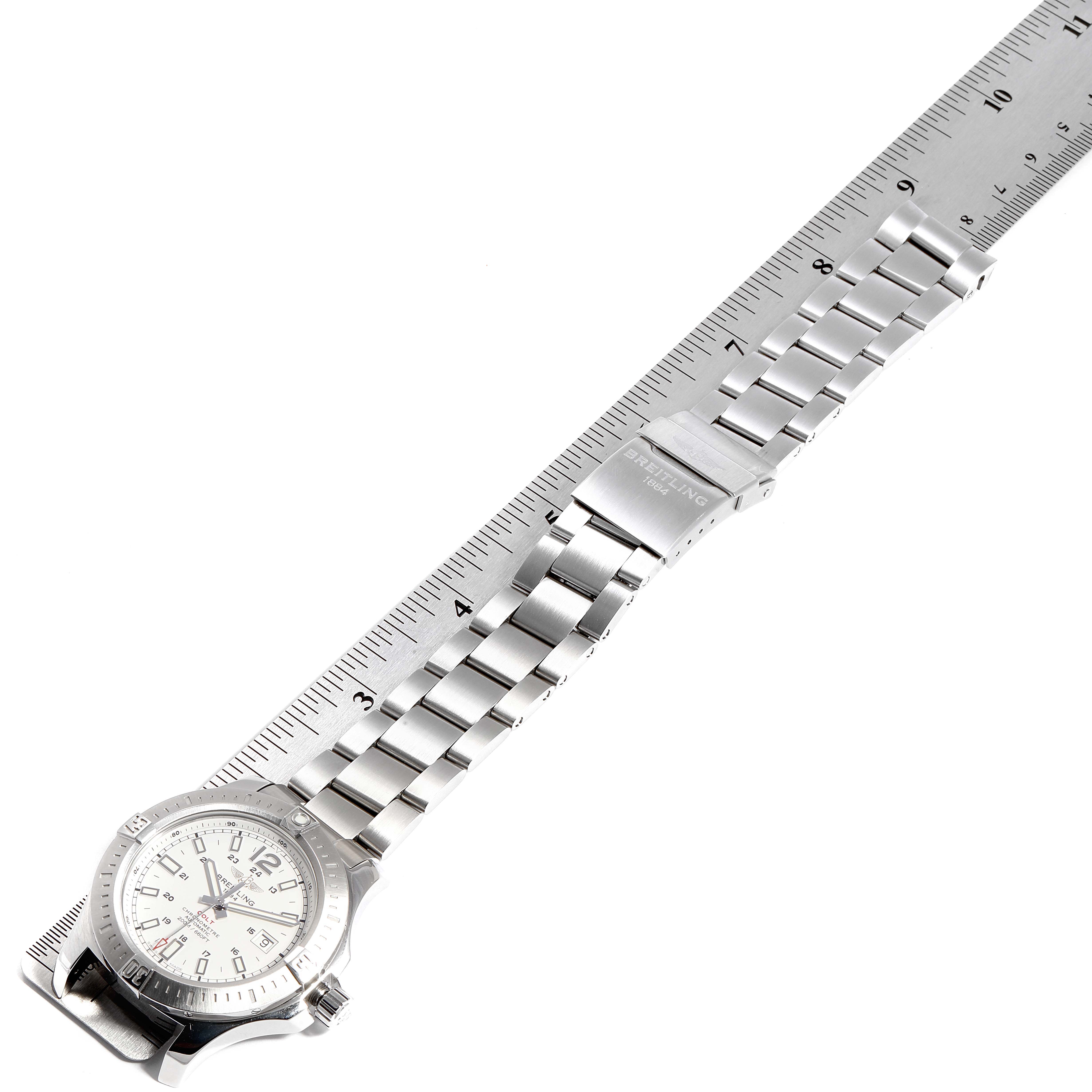 The image shows a Breitling Colt A17388 Men's Stainless Steel White Dial A17388 Men's Stainless Steel White Dial watch laid flat, with a ruler measuring its stainless steel bracelet and clasp.