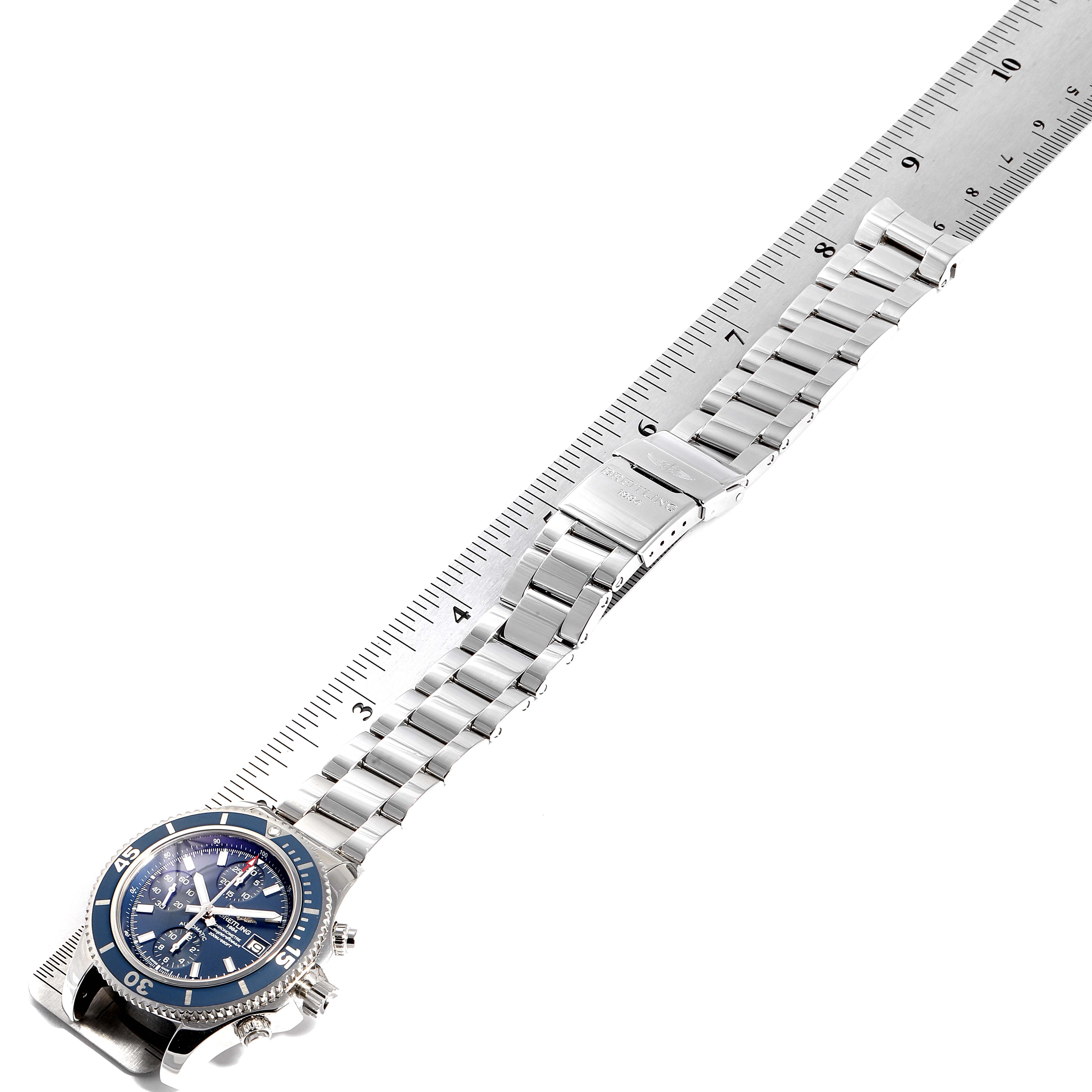 The image shows a Breitling Superocean A13311 Men's Stainless Steel Blue Dial A13311 Men's Stainless Steel Blue Dial watch placed on a ruler, displaying the watch face, bracelet, and clasp from a top-down angle.
