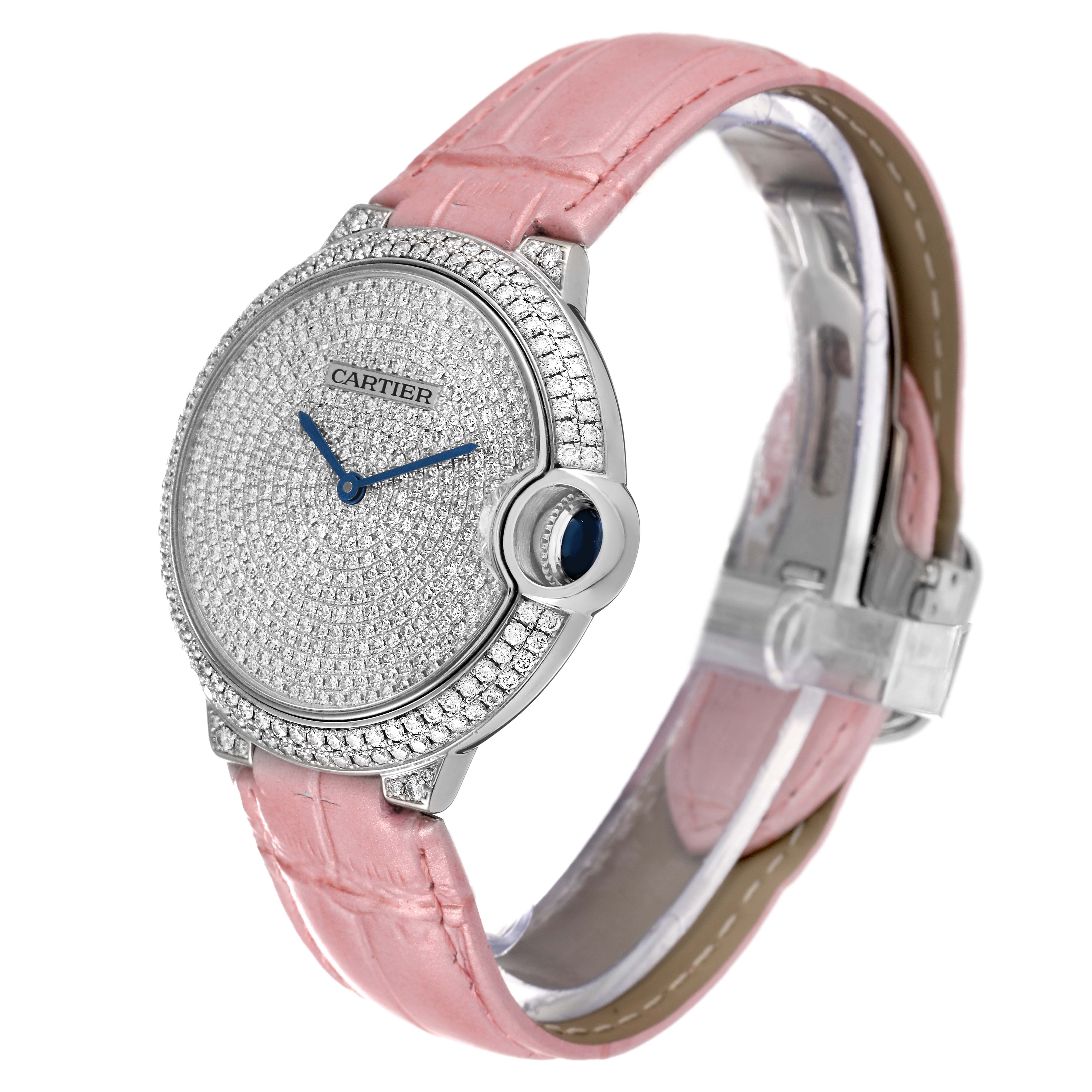 The Cartier Ballon Bleu WE902042 Women
s White Gold Silver Dial WE902042 Women
s White Gold Silver Dial watch is shown at a slight angle, displaying its diamond-studded face, blue hands, and pink leather strap.