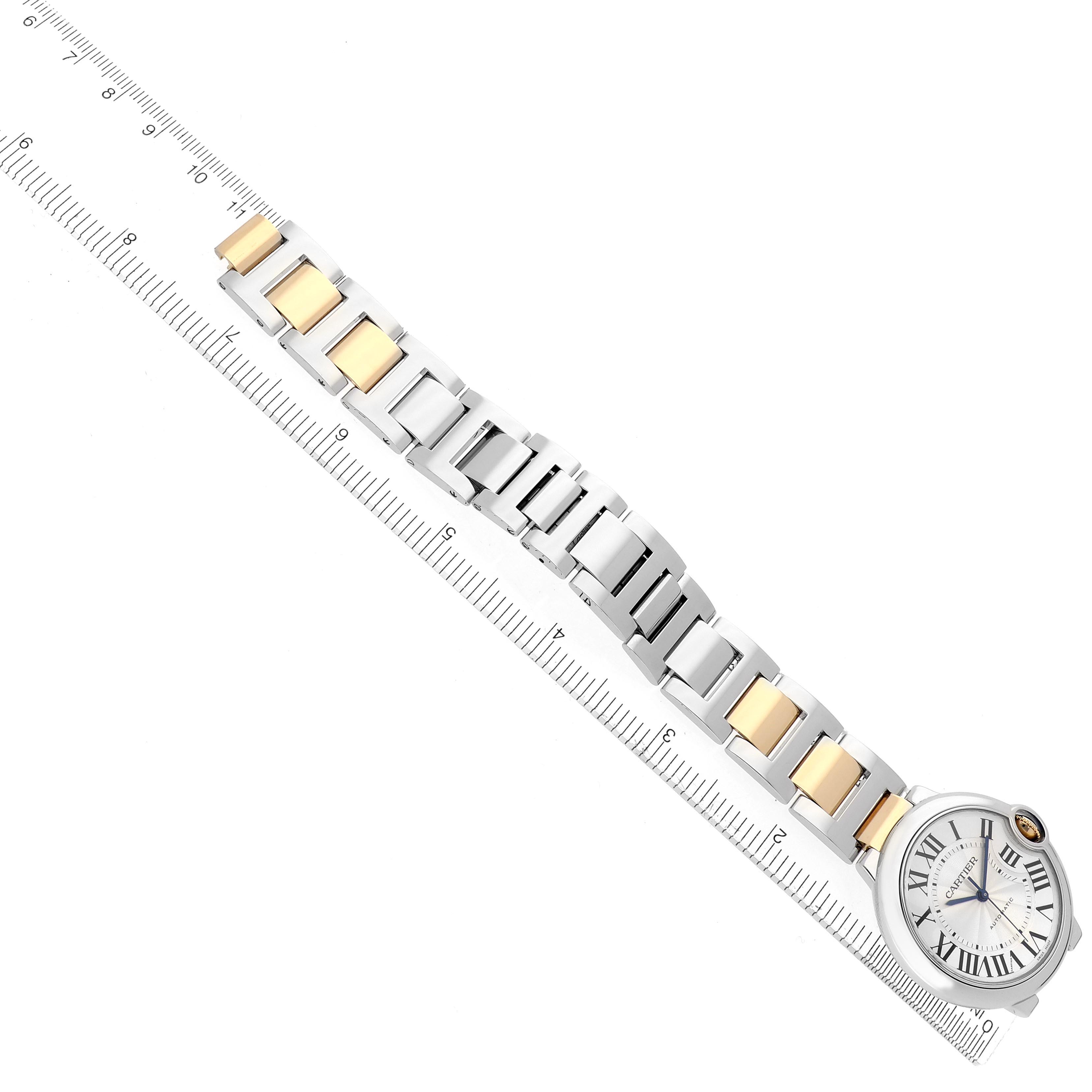 The Cartier Ballon Bleu W2BB0012 Women's Steel and Gold (two tone) Silver Dial W2BB0012 Women's Steel and Gold (two tone) Silver Dial watch is shown from above, highlighting its silver and gold bracelet and round face, alongside a ruler.
