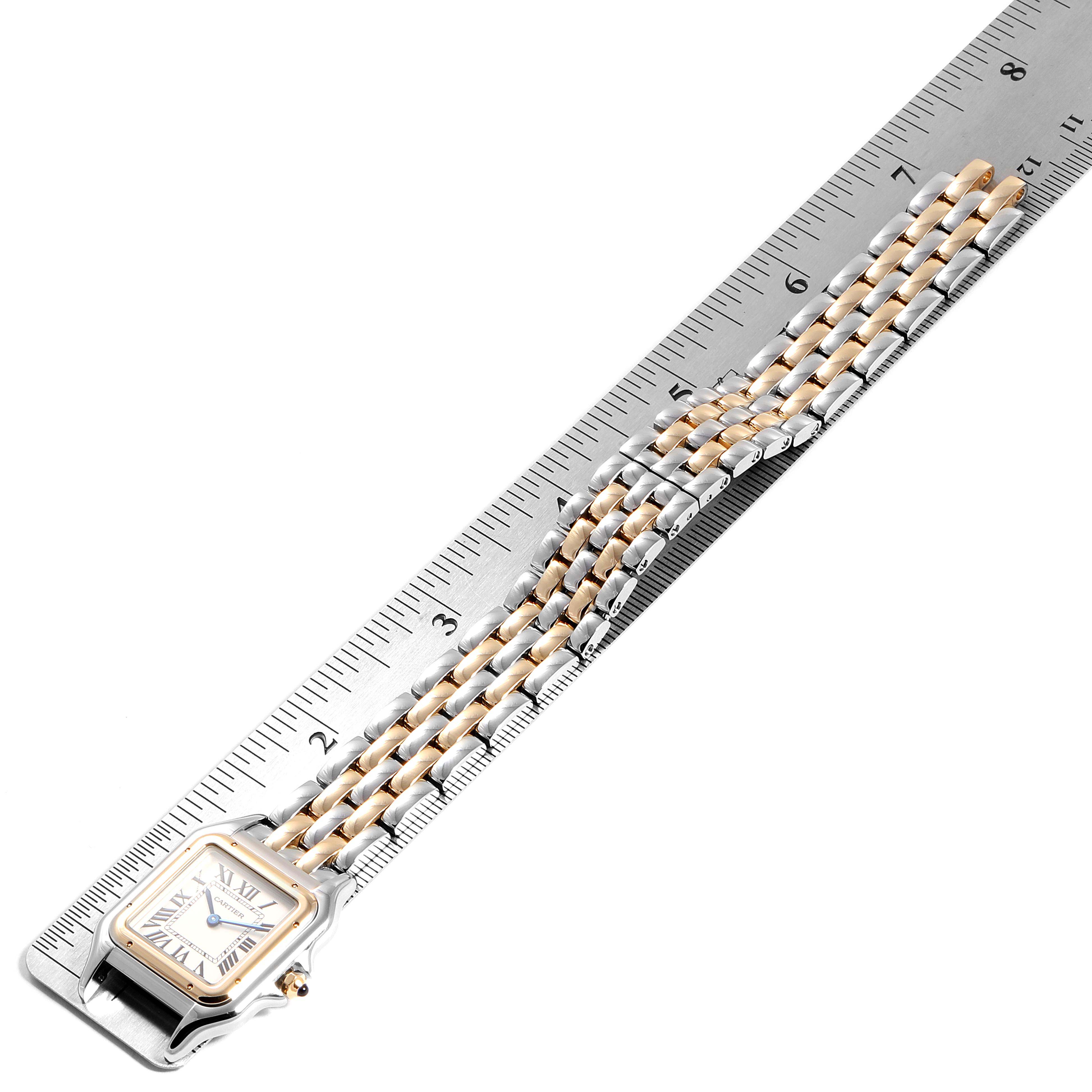 The Panthere watch by Cartier is shown horizontally with its bracelet next to a ruler for measurement.