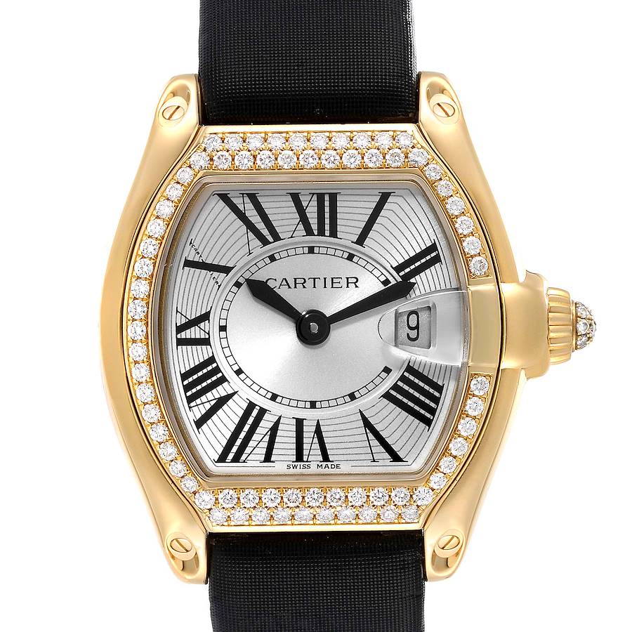 The Cartier Roadster watch is shown from the front, highlighting its dial, Roman numerals, date window, and diamond-encrusted bezel.