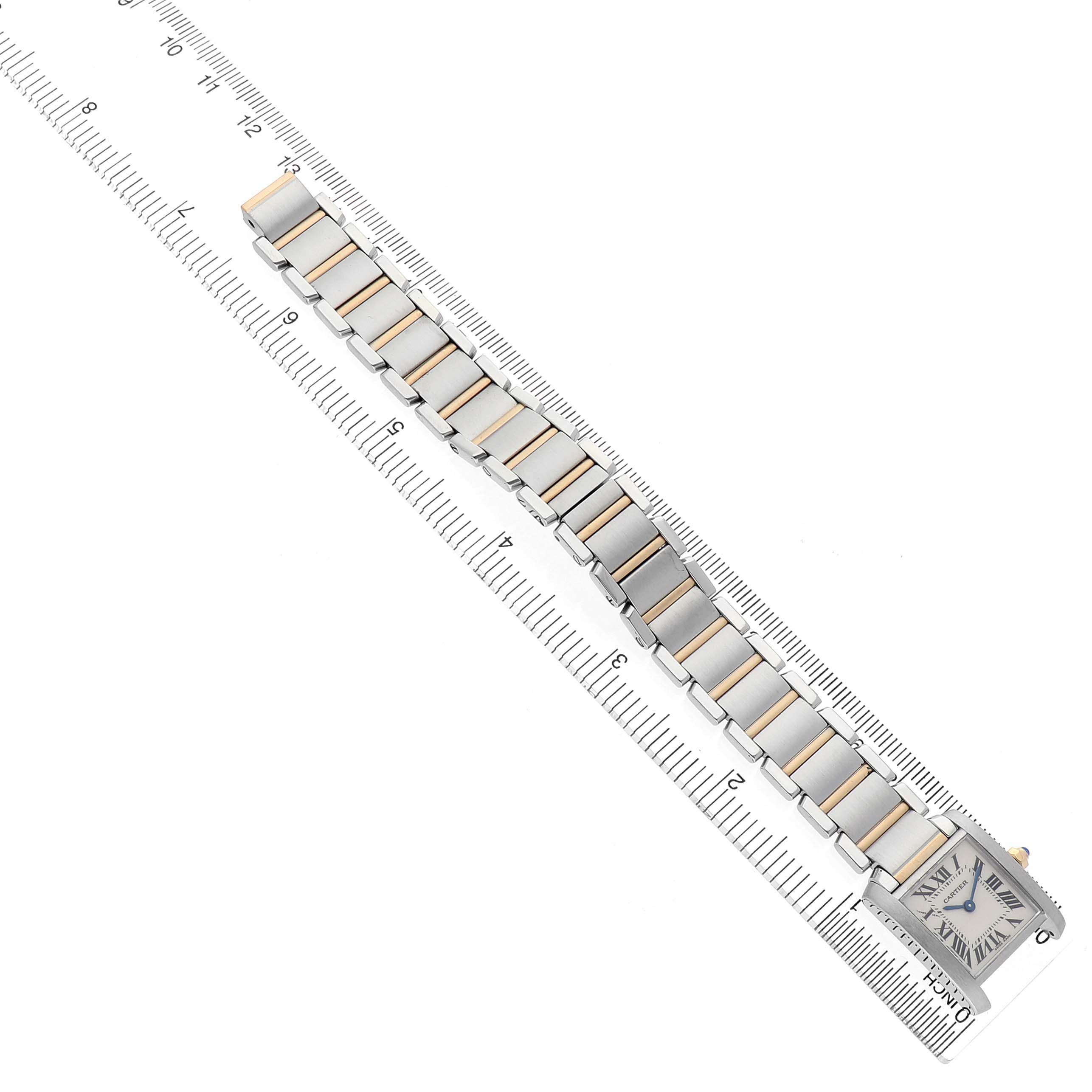 The Cartier Tank Francaise W51007Q4 Women's Steel and Gold (two tone) Silver Dial watch is shown diagonally, featuring its rectangular face and full metal bracelet on a ruler for scale.
