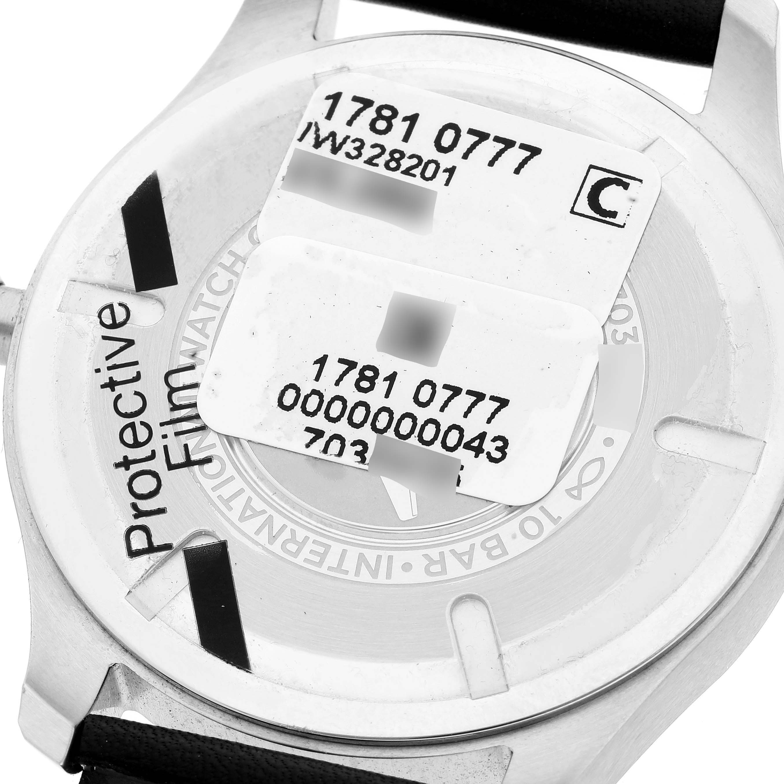 This image shows the back of an IWC Pilot IW328201 Men
s Stainless Steel Black Dial IW328201 Men
s Stainless Steel Black Dial model watch with protective film and serial number labels.