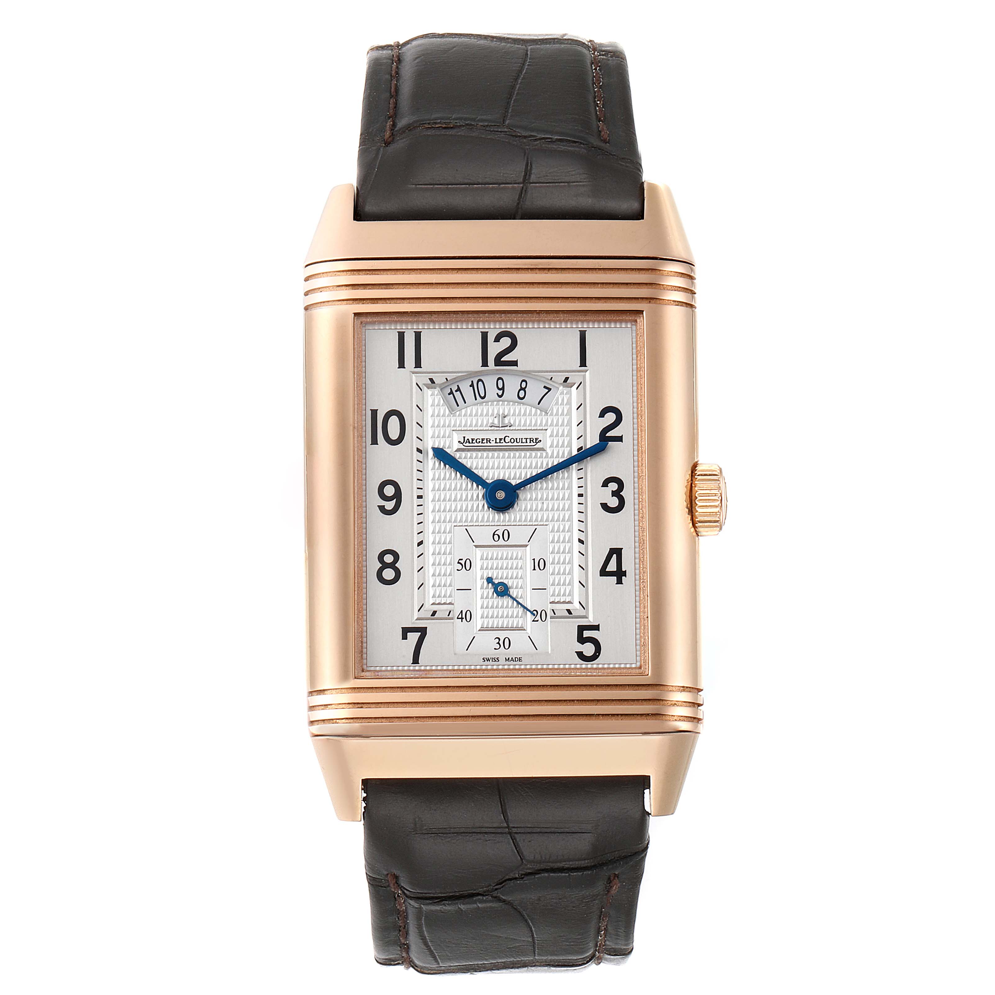 The Jaeger-LeCoultre Reverso watch is shown from the front, displaying its rectangular dial and brown leather strap.