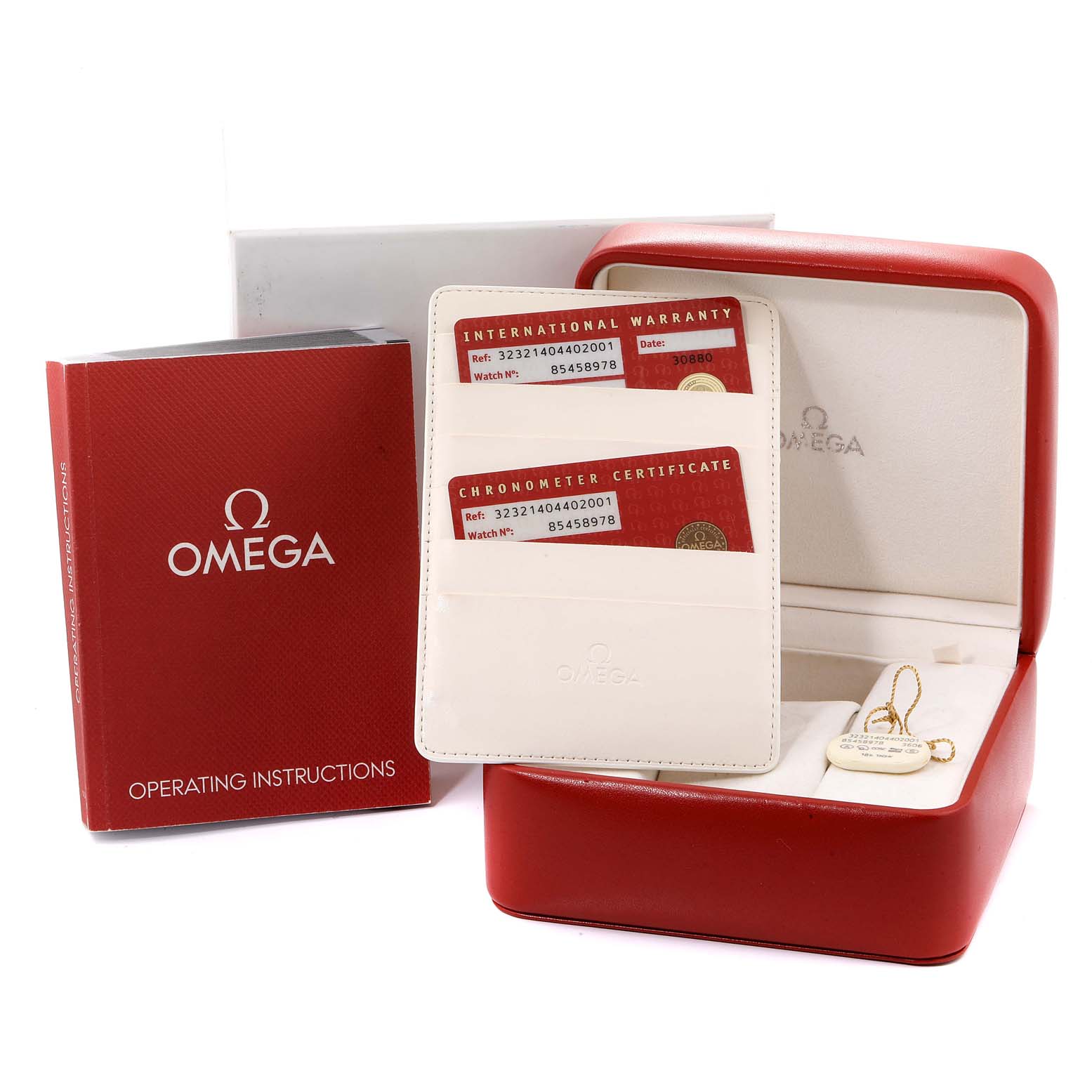 The image shows a red Omega Speedmaster 323.21.40.44.02.001 Men's Steel and Gold (two tone) Silver Dial 323.21.40.44.02.001 Men's Steel and Gold (two tone) Silver Dial box, warranty cards, operating instructions, and a hanging tag from a side angle.