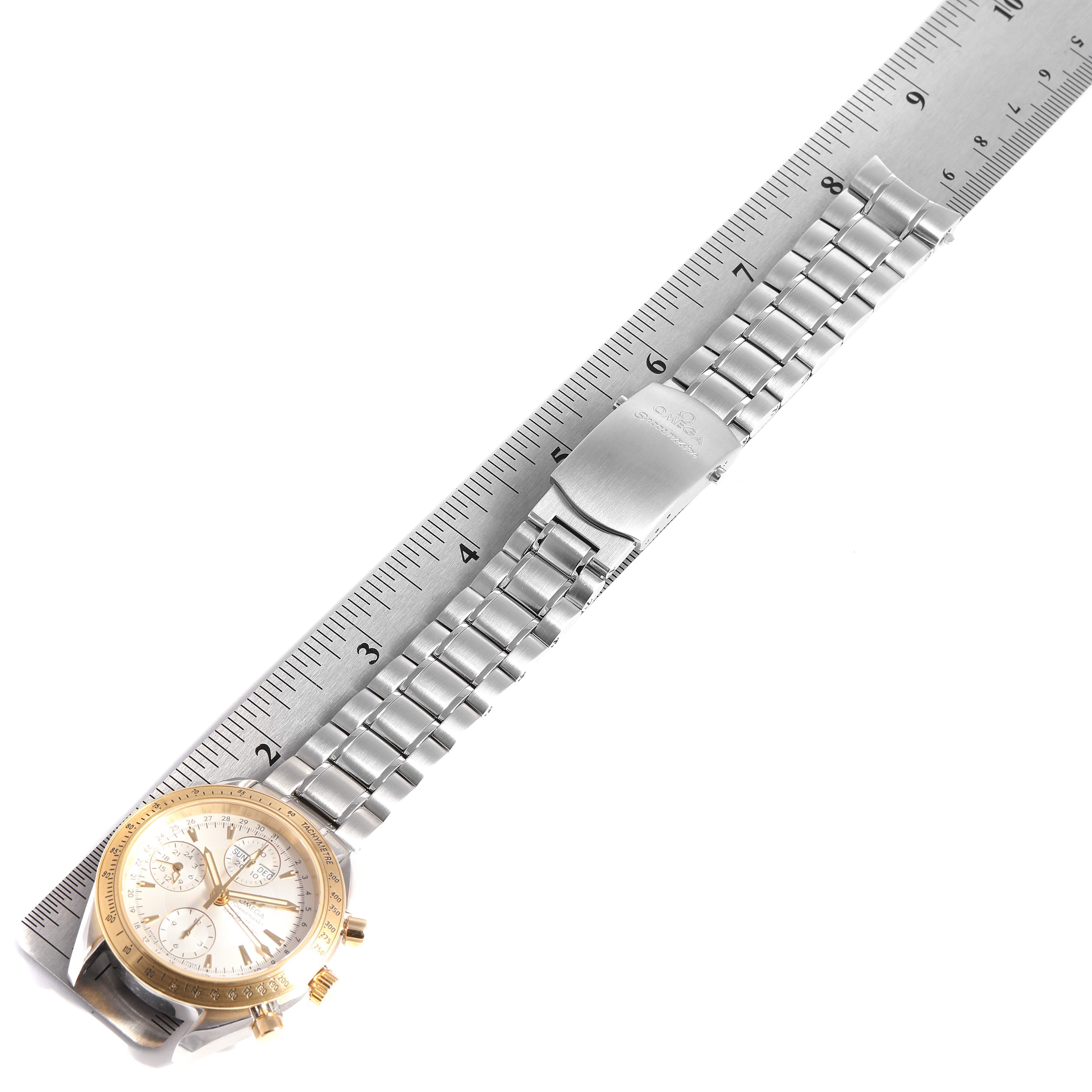 This image shows an Omega Speedmaster 323.21.40.44.02.001 Men's Steel and Gold (two tone) Silver Dial 323.21.40.44.02.001 Men's Steel and Gold (two tone) Silver Dial watch with a metal strap, clasp, and a ruler for scale.