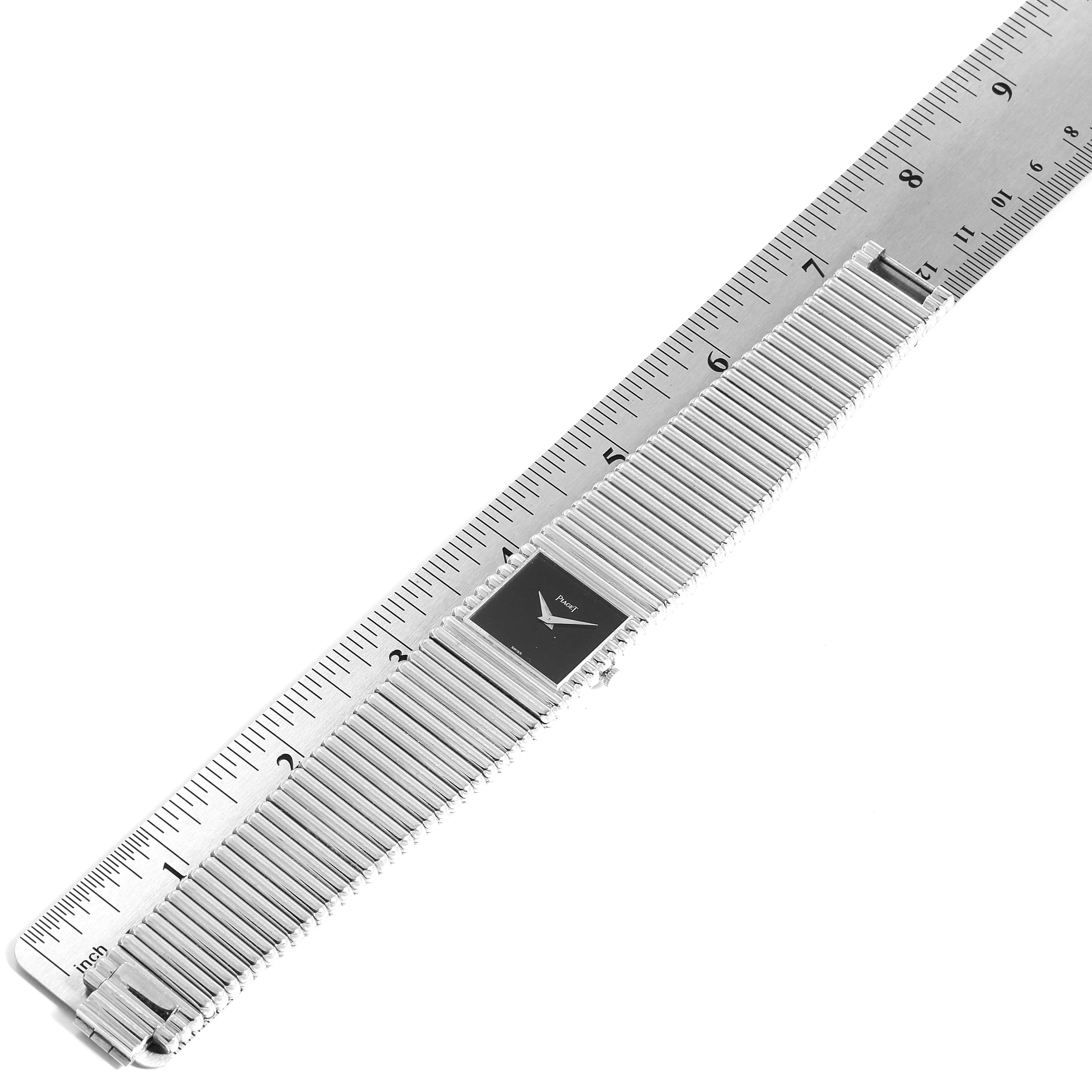 This image shows a Piaget 9131 C 10 Men
s White Gold Black Dial 9131 C 10 Men
s White Gold Black Dial Polo 18K White Gold Black Dial Men
s Watch 9131 laid flat with a ruler for scale.