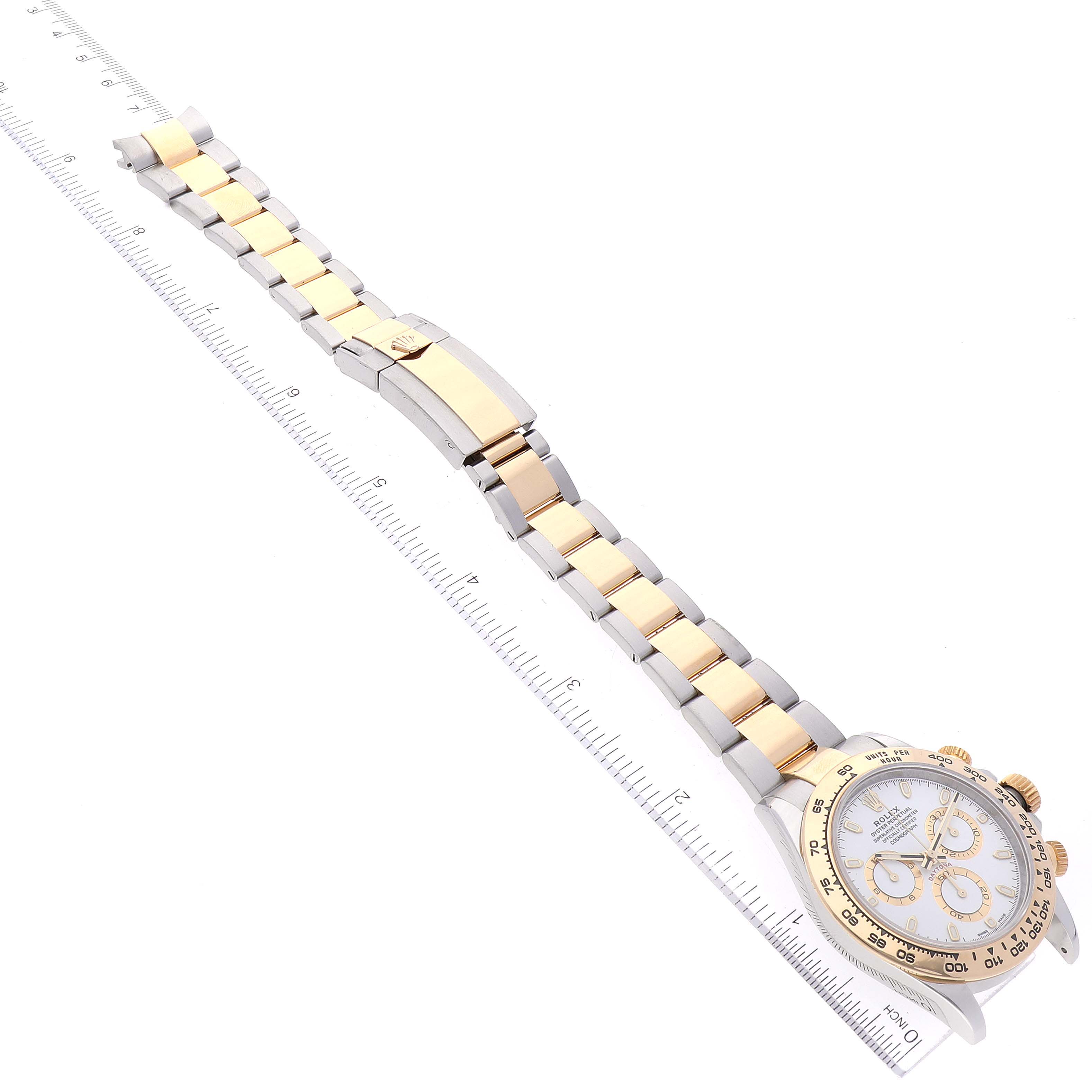 The image shows the Rolex Daytona 116503 Men
s Steel and Gold (two tone) White Dial 116503 Men
s Steel and Gold (two tone) White Dial watch laid flat with its gold and silver bracelet fully extended and a ruler for scale.
