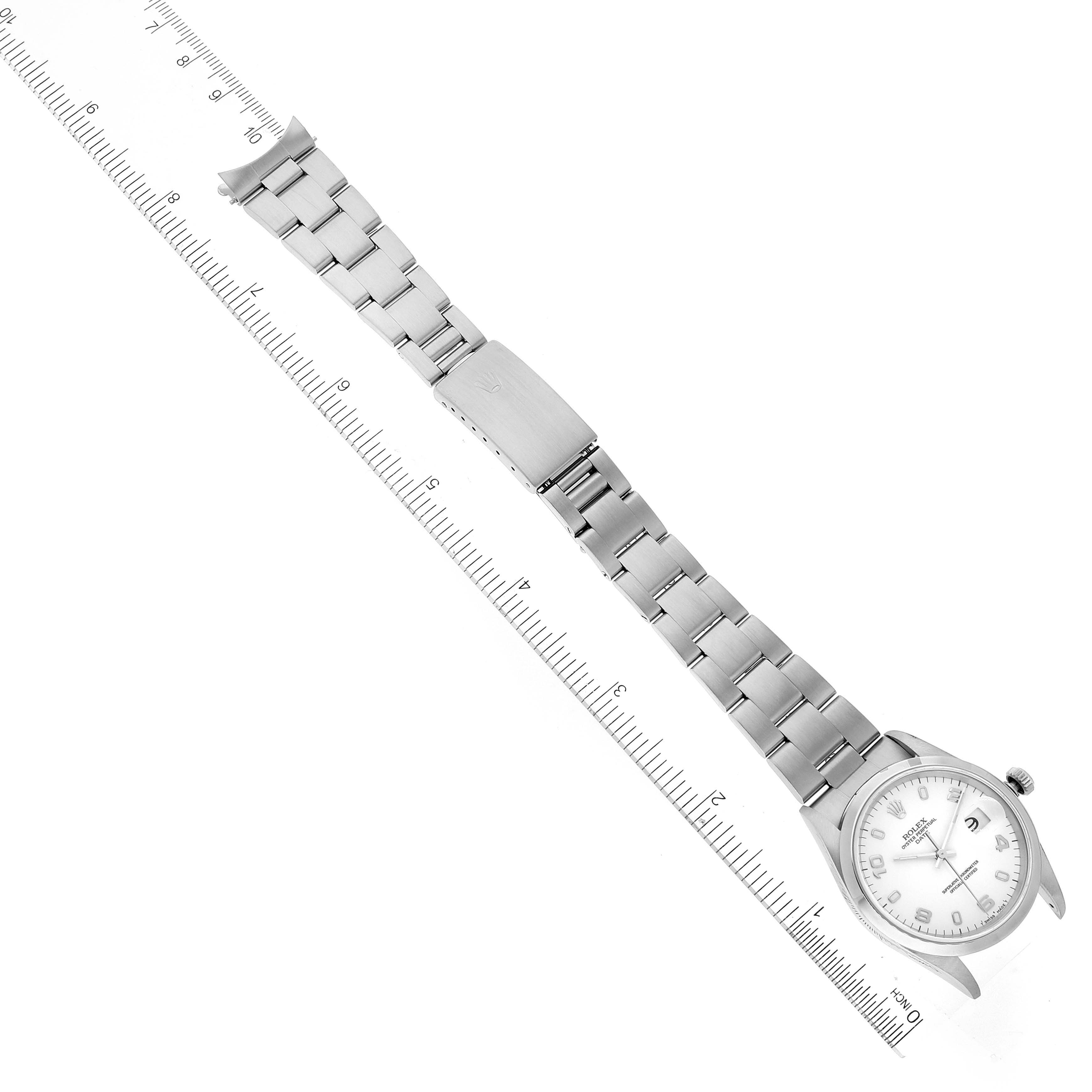 The Rolex Date 15200 Men's Stainless Steel White Dial 15200 Men's Stainless Steel White Dial model watch is shown from a top-down angle, fully extended with its bracelet and clasp visible, next to a ruler for scale.