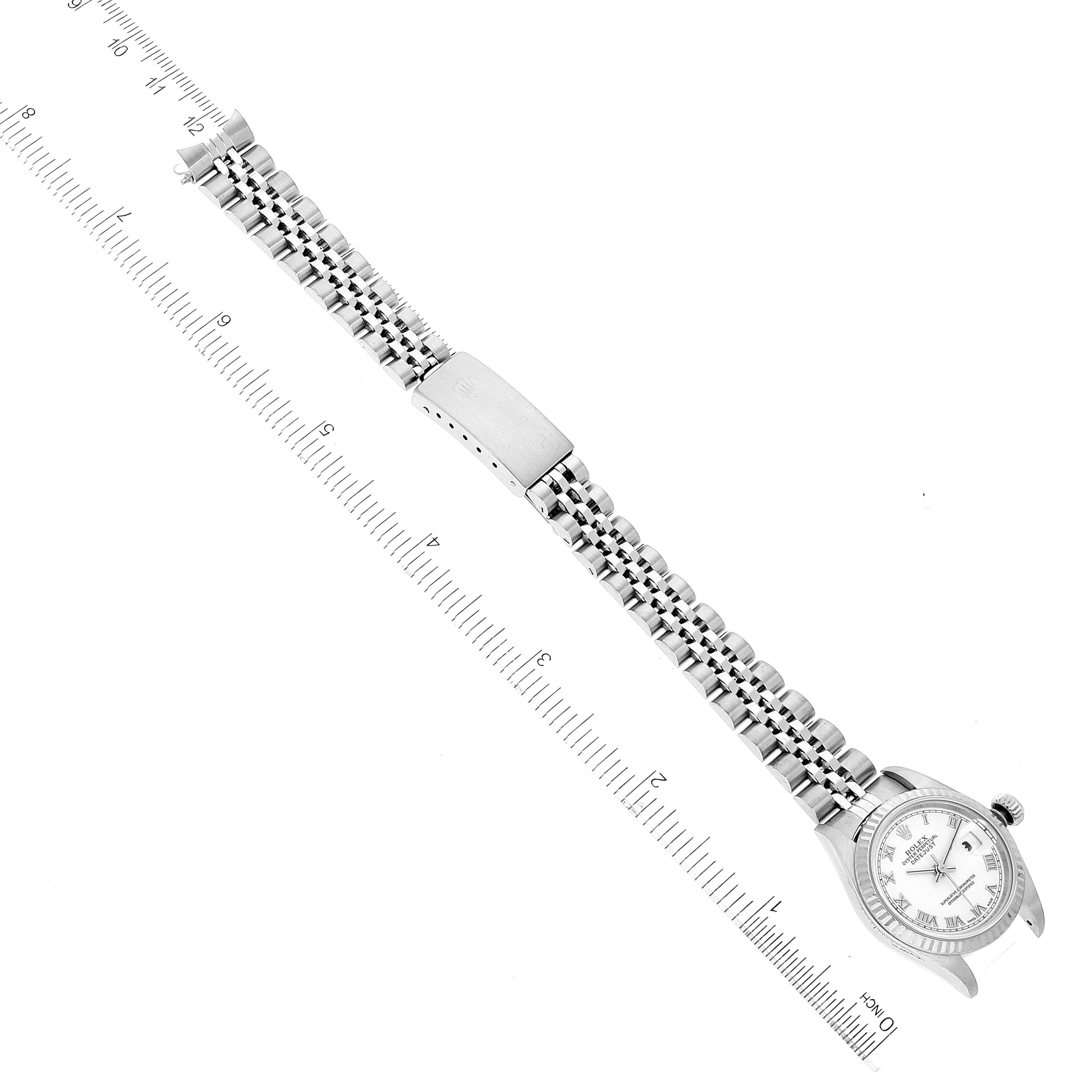 The image shows an overhead view of a Rolex Datejust 79174 Women's Stainless Steel White Dial 79174 Women's Stainless Steel White Dial watch with a metal bracelet, measured against a ruler.