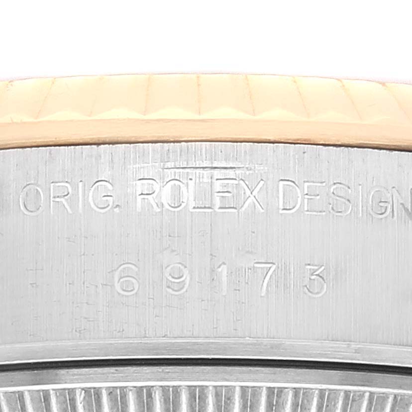This close-up image shows the case side of a Rolex Datejust 69173 Women's Steel and Gold (two tone) Champagne Dial 69173 Women's Steel and Gold (two tone) Champagne Dial watch, displaying the model number and "ORIG. ROLEX DESIGN."