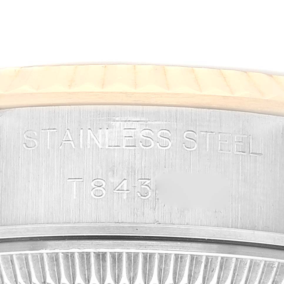 This close-up image shows the side of a Rolex Datejust 69173 Women's Steel and Gold (two tone) Champagne Dial 69173 Women's Steel and Gold (two tone) Champagne Dial watch with engravings on the stainless steel case.