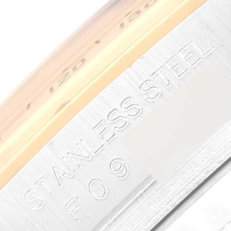 The image shows a close-up of the side of a Rolex Daytona 116523 Men
s Steel and Gold (two tone) White Dial 116523 Men
s Steel and Gold (two tone) White Dial watch, highlighting the "STAINLESS STEEL" engraving.