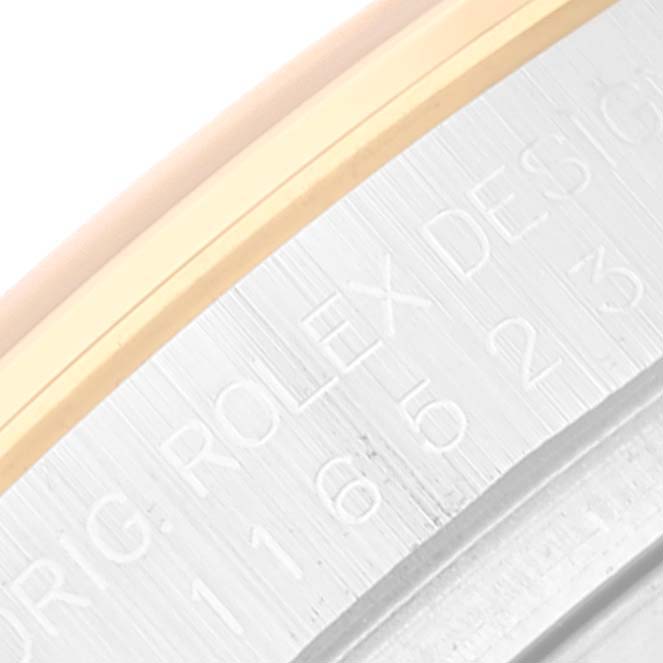 This close-up image shows the engraved inner bezel of a Rolex Daytona 116523 Men
s Steel and Gold (two tone) White Dial 116523 Men
s Steel and Gold (two tone) White Dial watch.