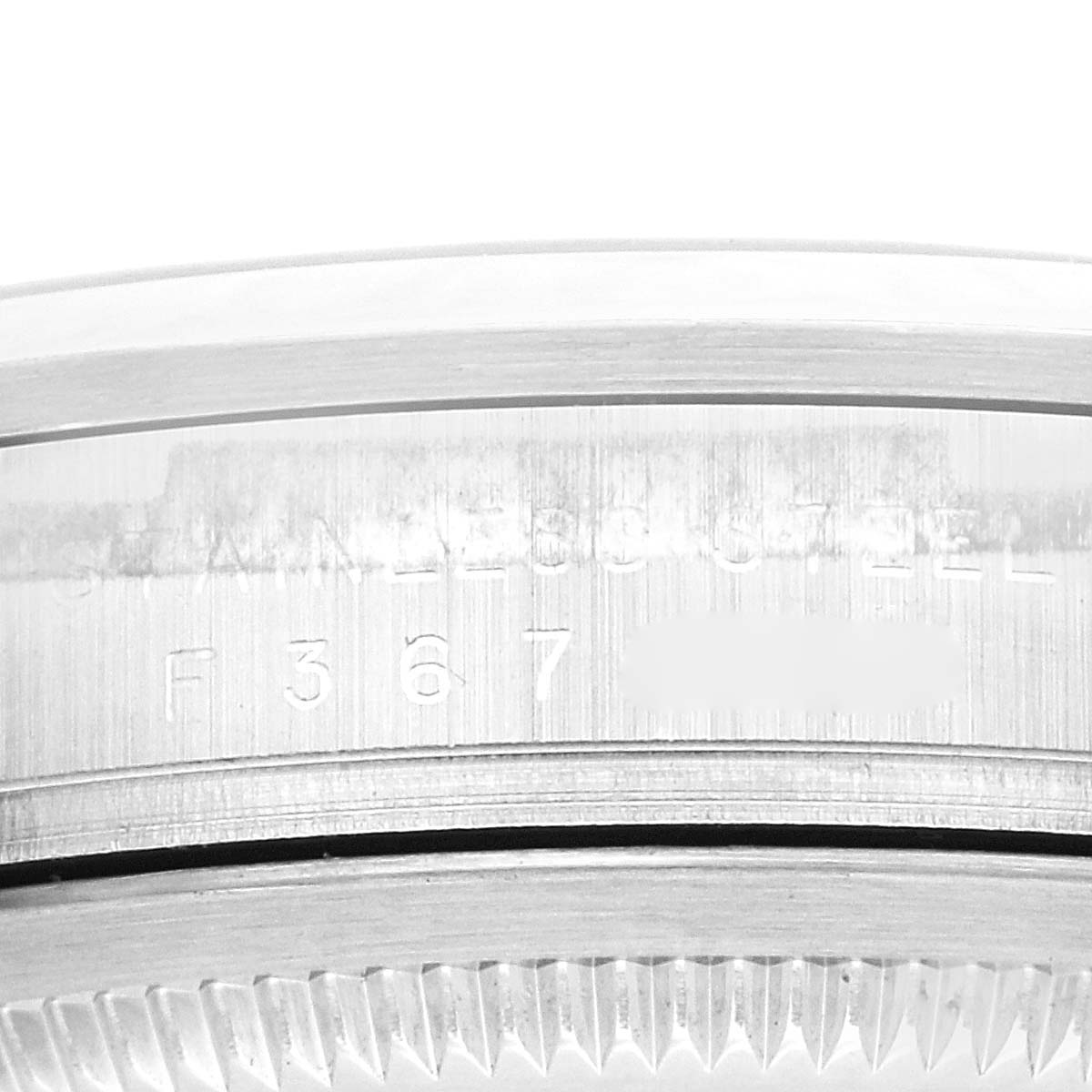 The image shows a close-up side view of the serial number engraving on the bezel of a Rolex Explorer 114270 Men
s Stainless Steel Black Dial 114270 Men
s Stainless Steel Black Dial watch.