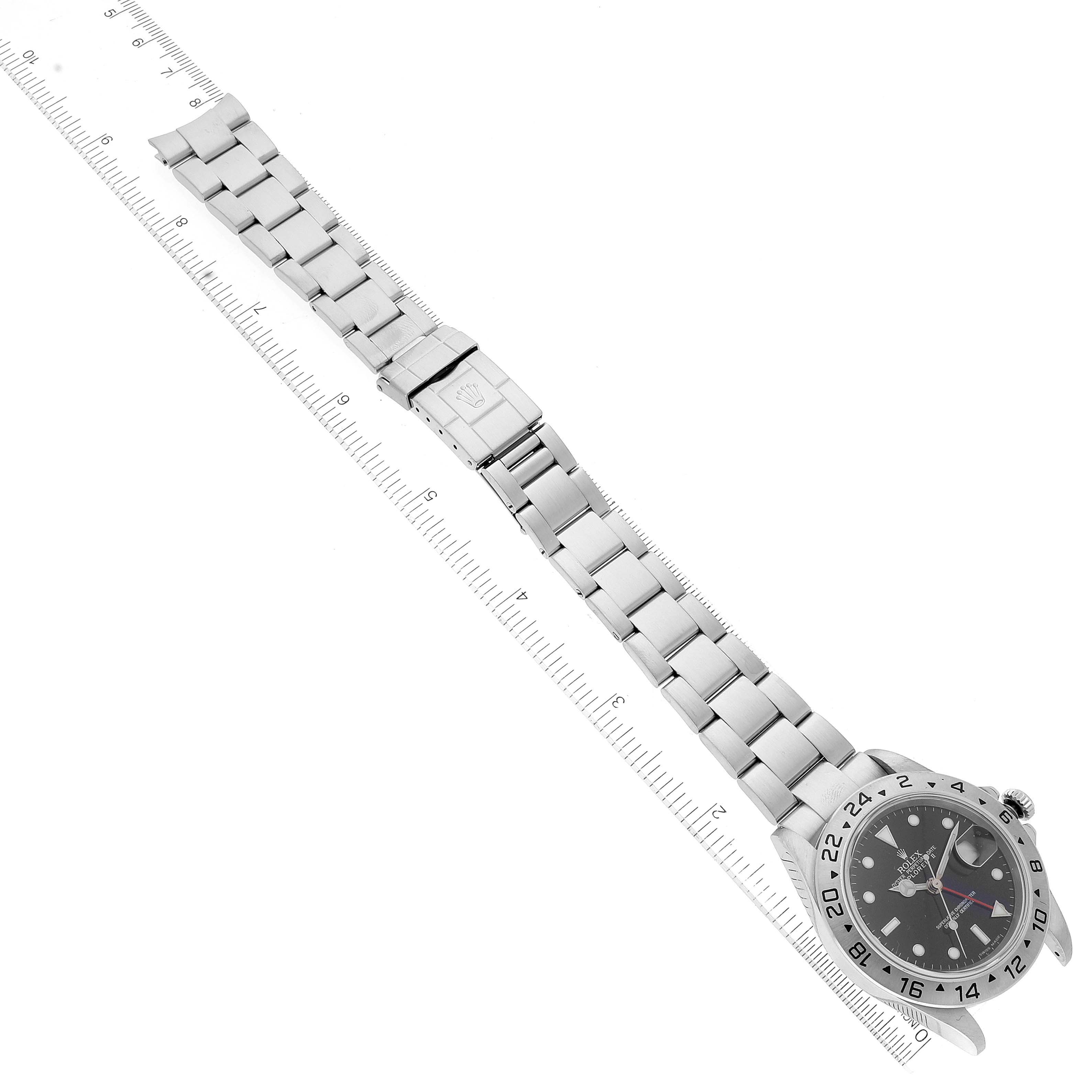 The image shows the Rolex Explorer 16570 Men's Stainless Steel Black Dial 16570 Men's Stainless Steel Black Dial watch laid flat with its stainless steel bracelet and clasp visible, accompanied by a measuring scale.