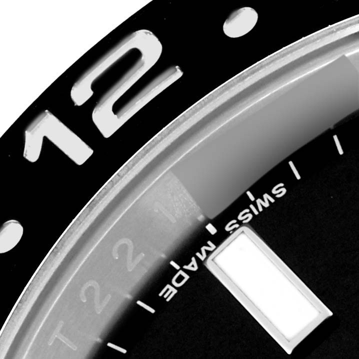 The image shows a close-up of the bezel and part of the dial of a Rolex GMT-Master 116710 Men
s Stainless Steel Black Dial 116710 Men
s Stainless Steel Black Dial watch, including the "12" marker and "SWISS MADE" text.