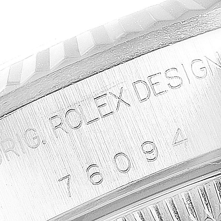 This image shows a close-up of the casing of a Rolex Oyster Perpetual 76094 Women's Stainless Steel Pink Dial 76094 Women's Stainless Steel Pink Dial model, highlighting the engraved text and part of the bezel.