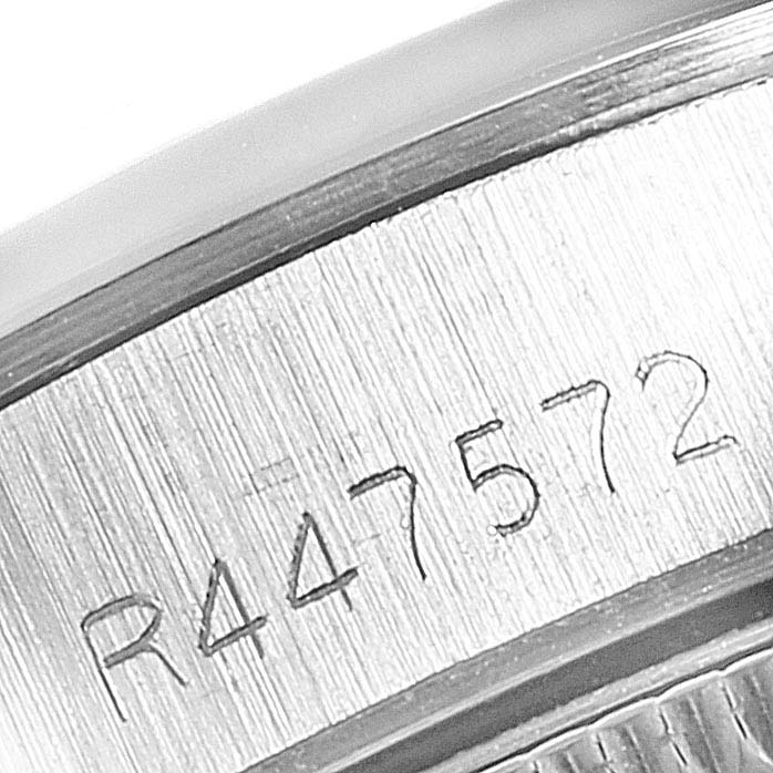 This close-up image shows the engraved serial number on the side of a Rolex Oyster Perpetual 67180 Women's Stainless Steel Silver Dial 67180 Women's Stainless Steel Silver Dial watch.