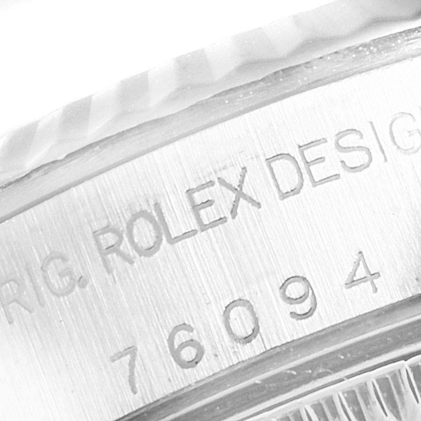 This image shows a close-up of the engraved reference number and "Rolex Design" on the side of the Rolex Oyster Perpetual 76094 Women's Stainless Steel Silver Dial 76094 Women's Stainless Steel Silver Dial watch case.