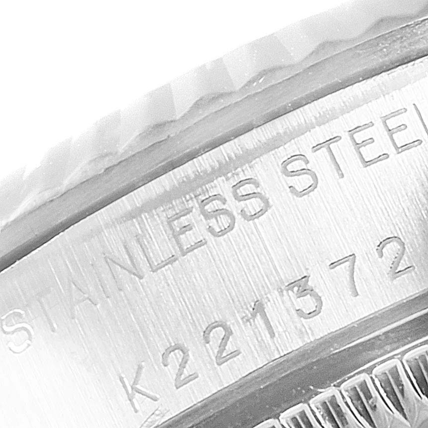The image shows a close-up of the side of the Rolex Oyster Perpetual 76094 Women's Stainless Steel Silver Dial 76094 Women's Stainless Steel Silver Dial watch, focusing on the engraved stainless steel casing and serial number.