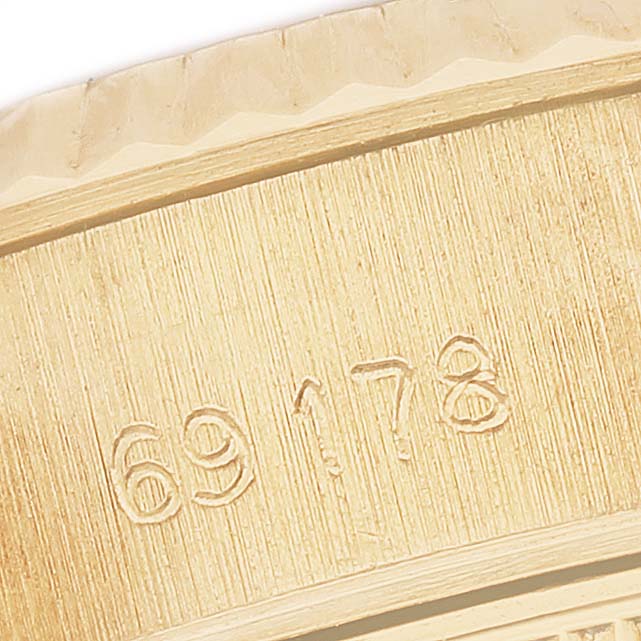 The image shows a close-up of the bezel and case with engraved numbers of the Rolex President 69178 Women's Yellow Gold Grey Dial model.