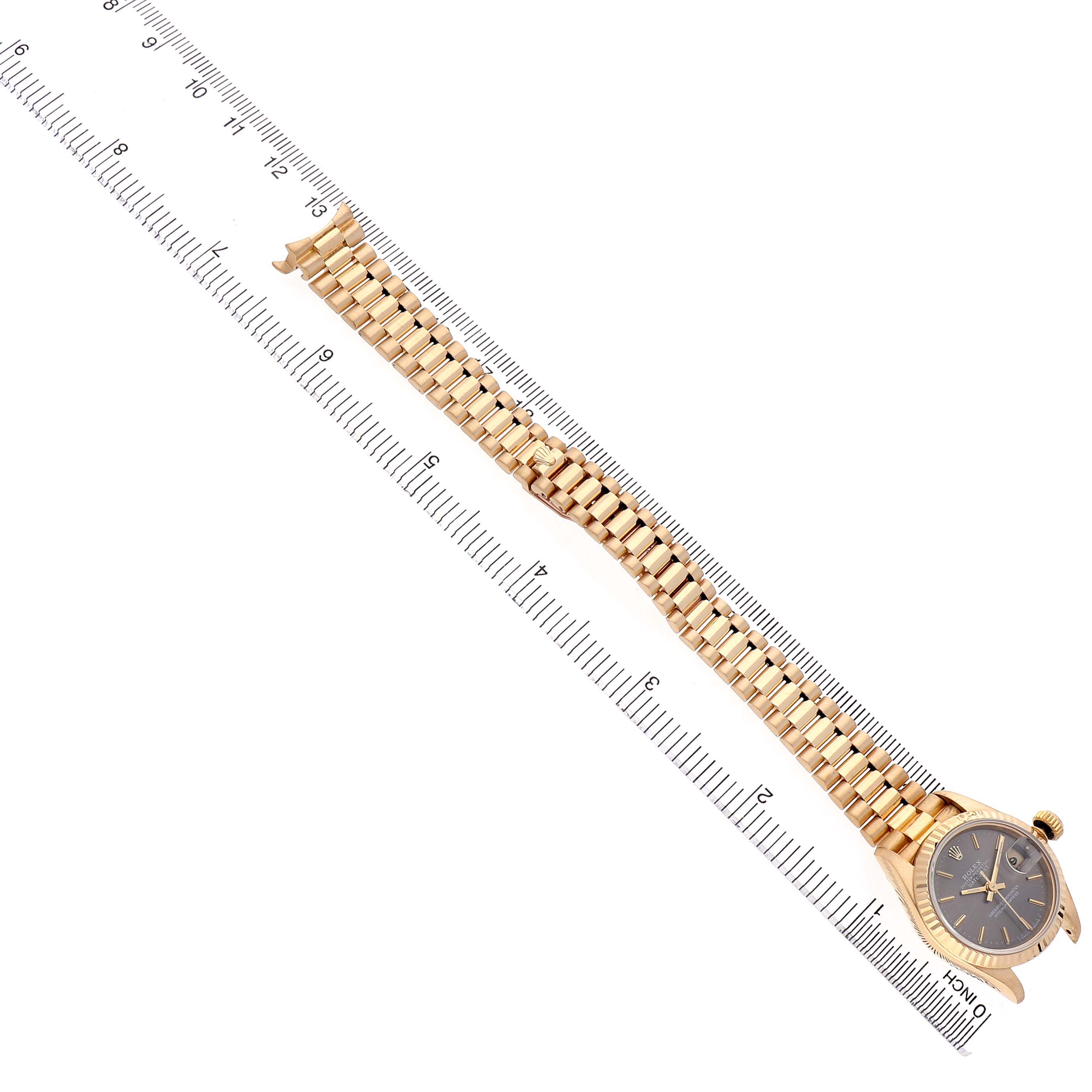 The image shows the Rolex President 69178 Women's Yellow Gold Grey Dial model watch at an angled view, displaying its full bracelet and case beside a ruler.