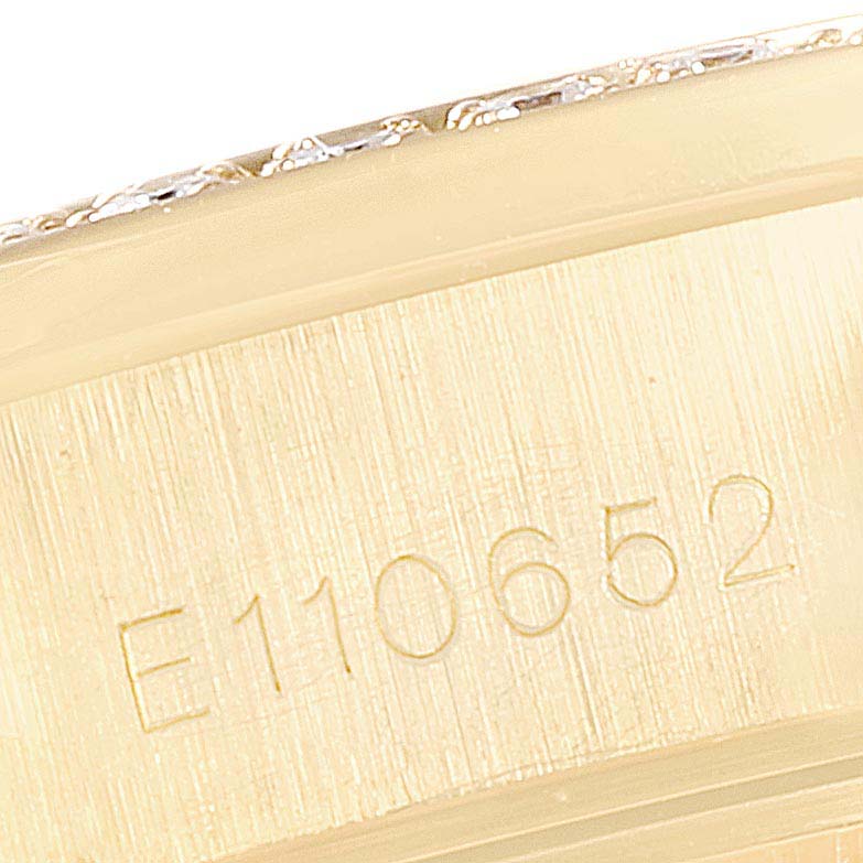 This close-up image shows the engraved serial number on the gold underside of the bezel of a Rolex President 69158 Women
s Yellow Gold Champagne Dial 69158 Women
s Yellow Gold Champagne Dial model watch.