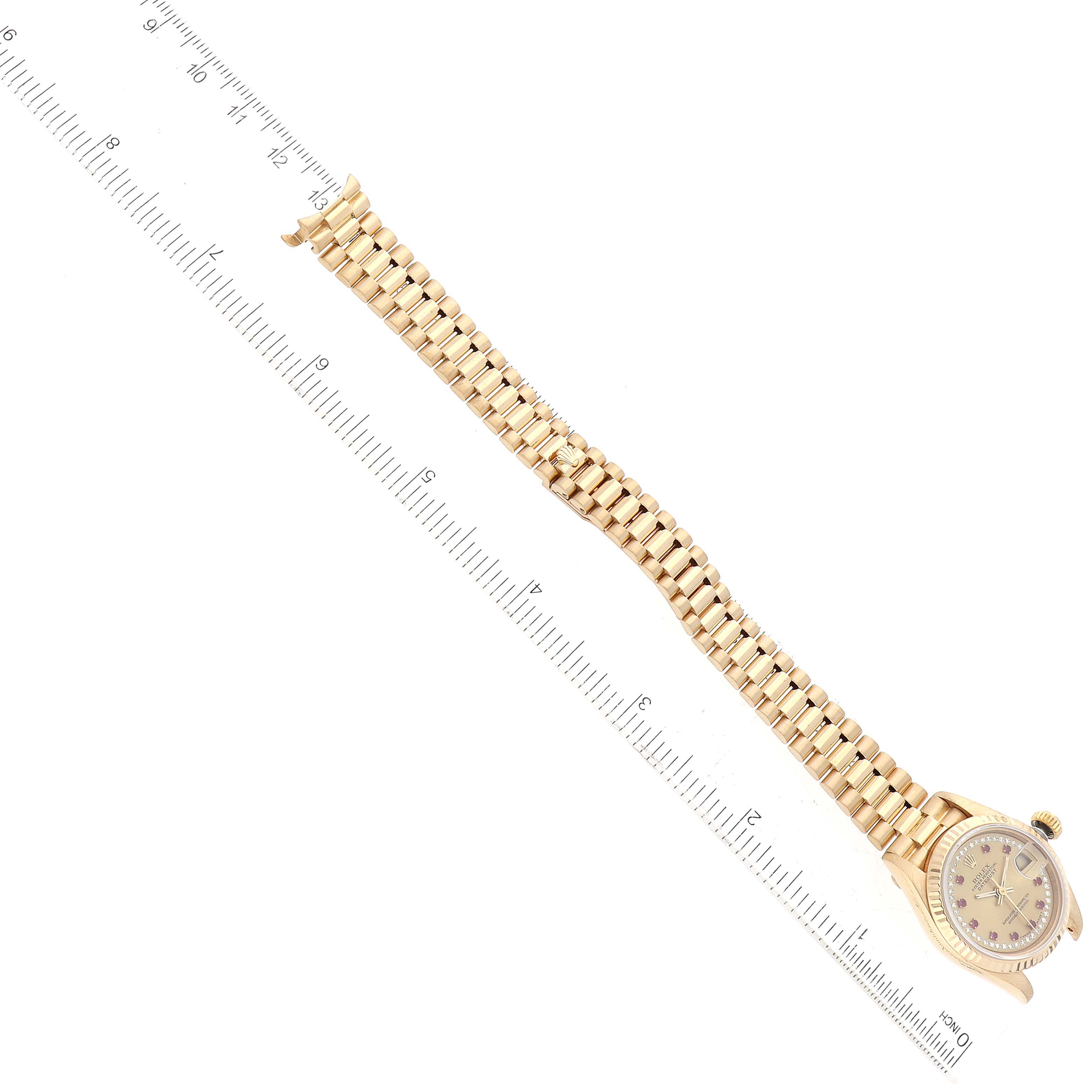 This image shows a Rolex President 69178 Women's Yellow Gold Champagne Dial 69178 Women's Yellow Gold Champagne Dial model watch angled diagonally with a focus on its band and face, placed next to a ruler for scale.