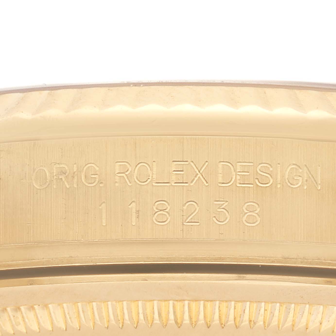 The image shows the side view of the Rolex President 118238 Men's Yellow Gold White Dial 118238 Men's Yellow Gold White Dial model, focusing on the engraved serial number and design marking.
